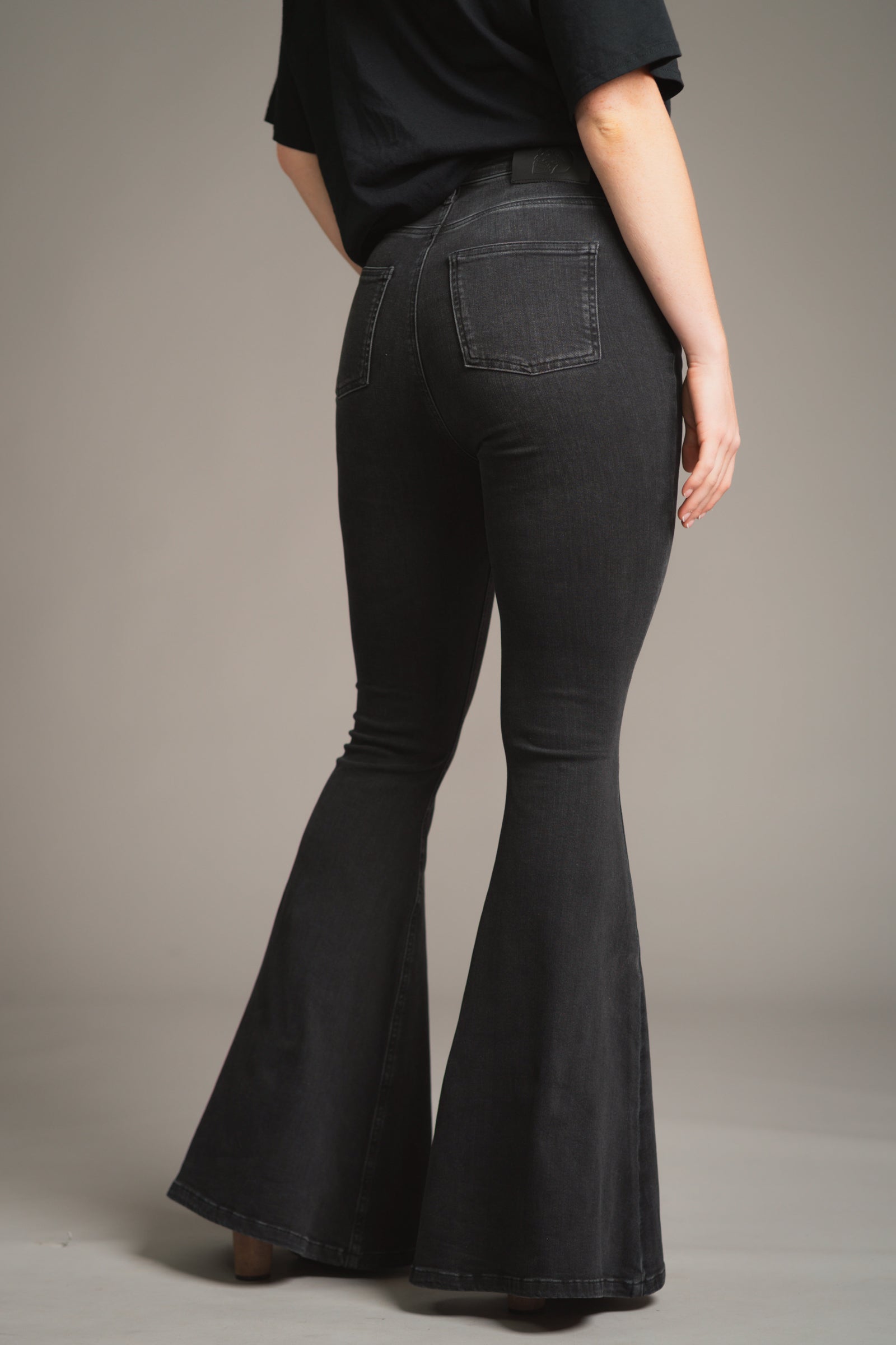 Close-up of the back of Little Lies Hendrix Denim Flares – dark wash denim with a smooth, slightly stretchy texture, contouring the hips with visible seam stitching and a sleek flare from the knee.