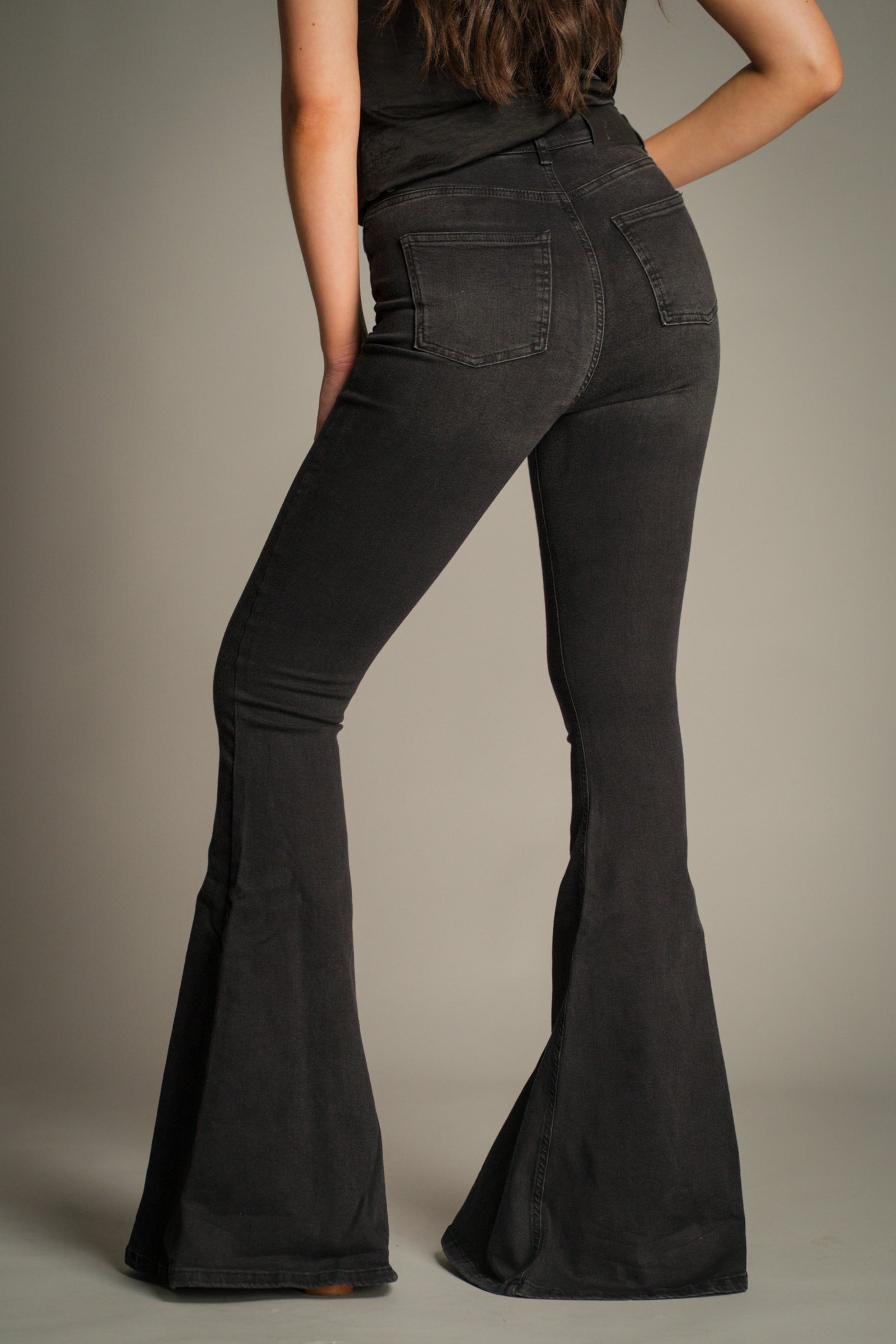 Back view of Hendrix Denim Flares in washed black with rear patch pockets, high-waisted fit and dramatic flare leg