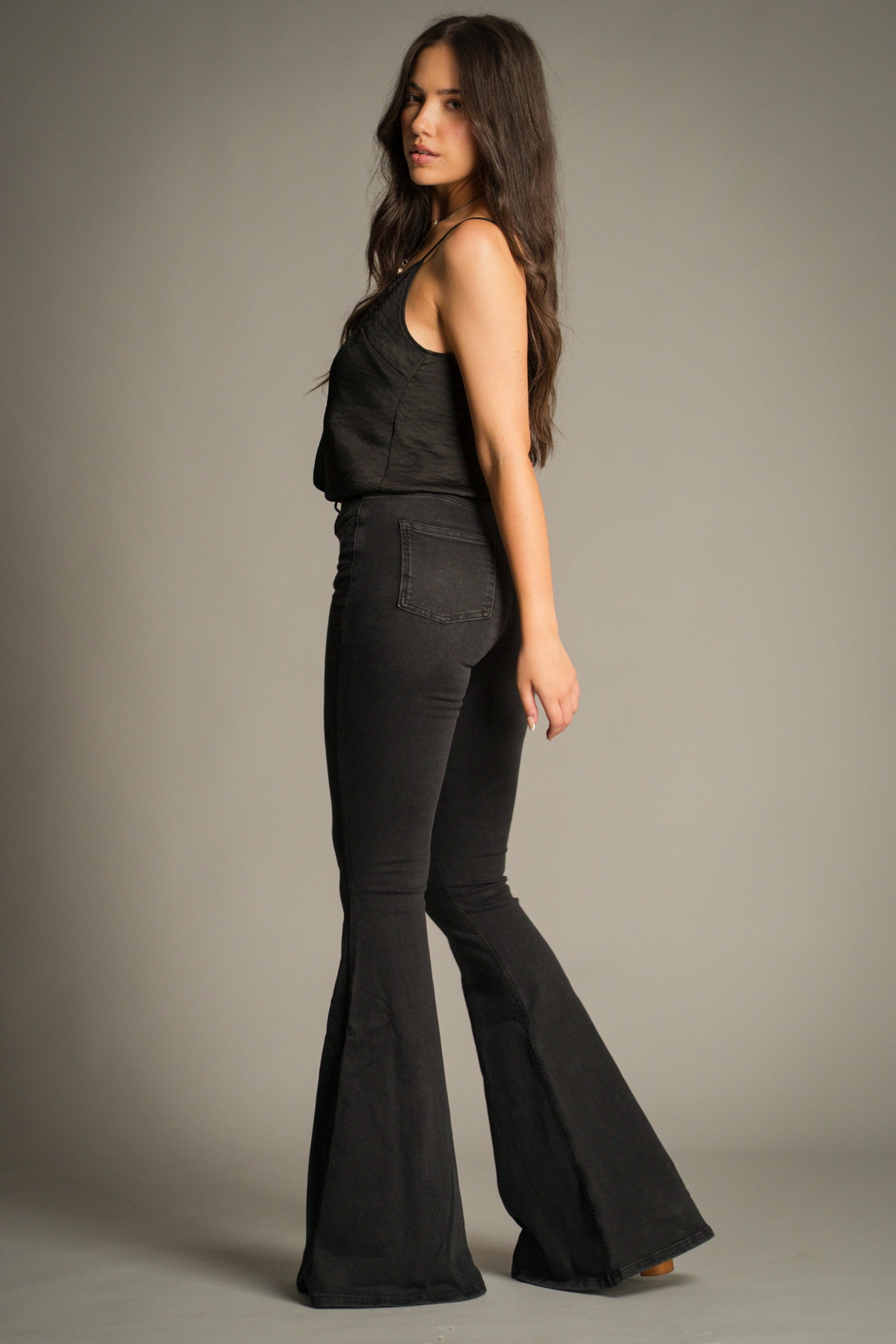Side profile of Hendrix Denim Flares in washed black showcasing the slim fit through the thigh and full-length flare hem