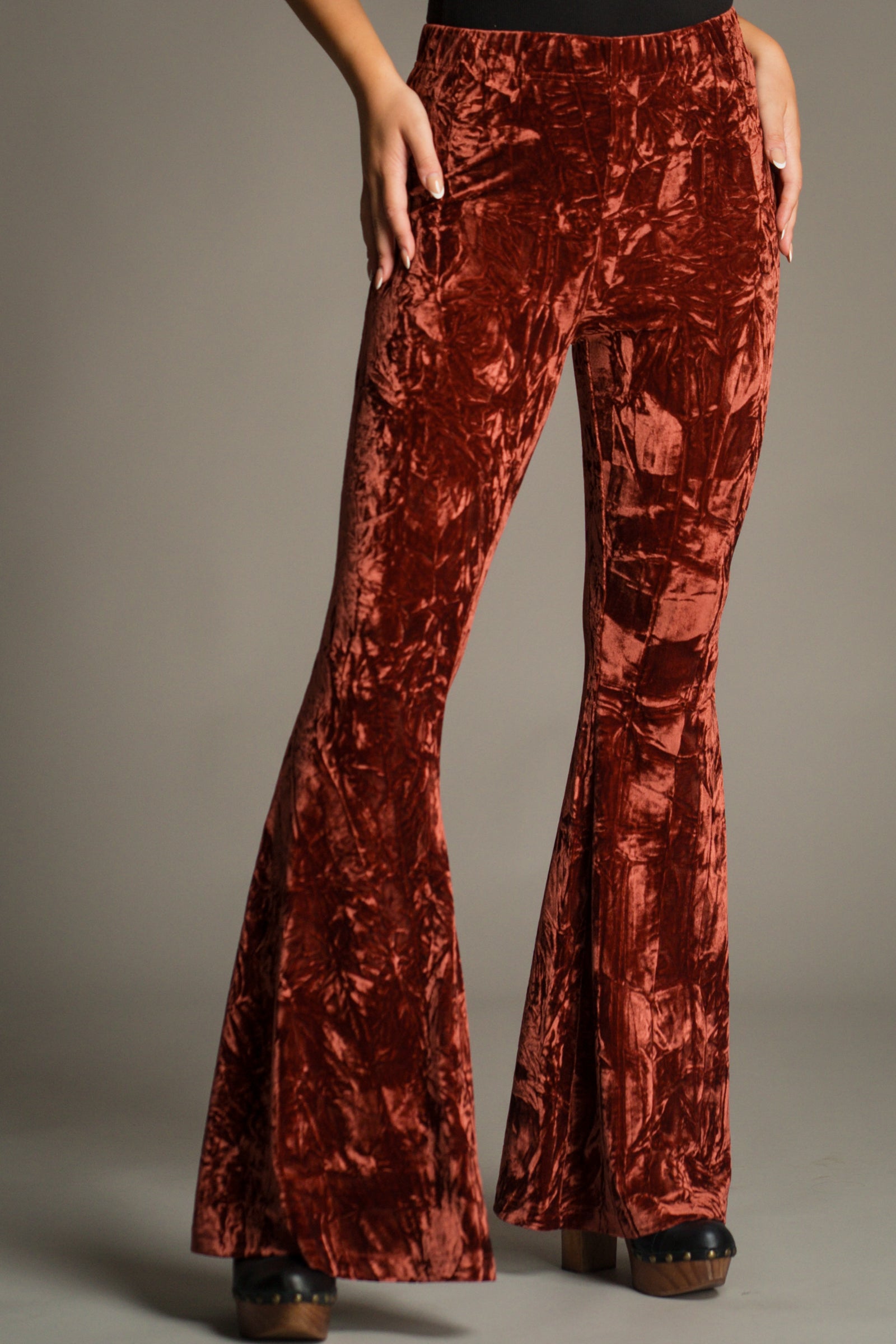 Close-up front view of Hendrix Rust Crushed Velvet Flares featuring a high-rise fit, soft stretch velvet fabric and dramatic flared leg