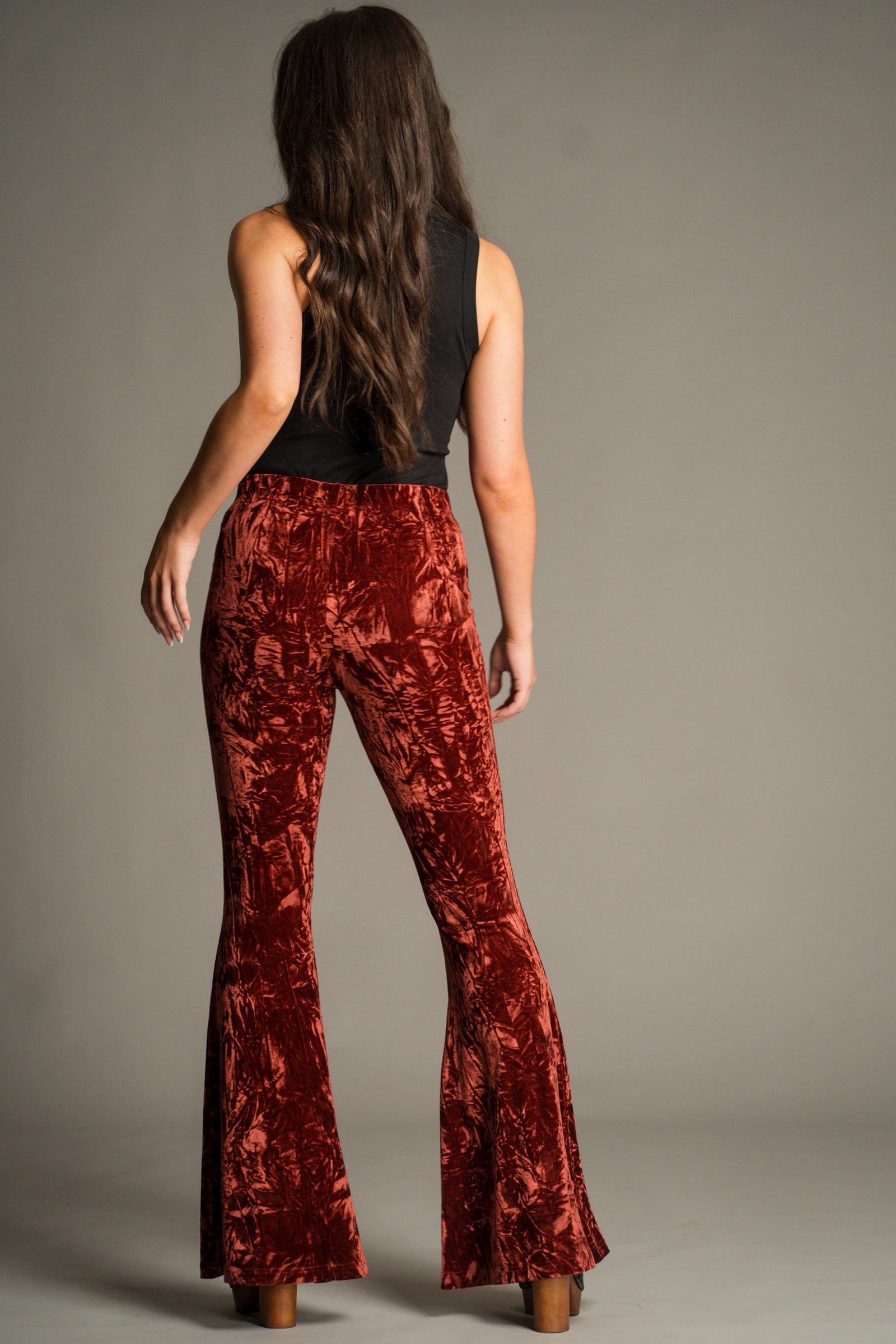 Back view of Hendrix Rust Crushed Velvet Flares showcasing the sculpting fit, comfortable waistband and full-length flared hem