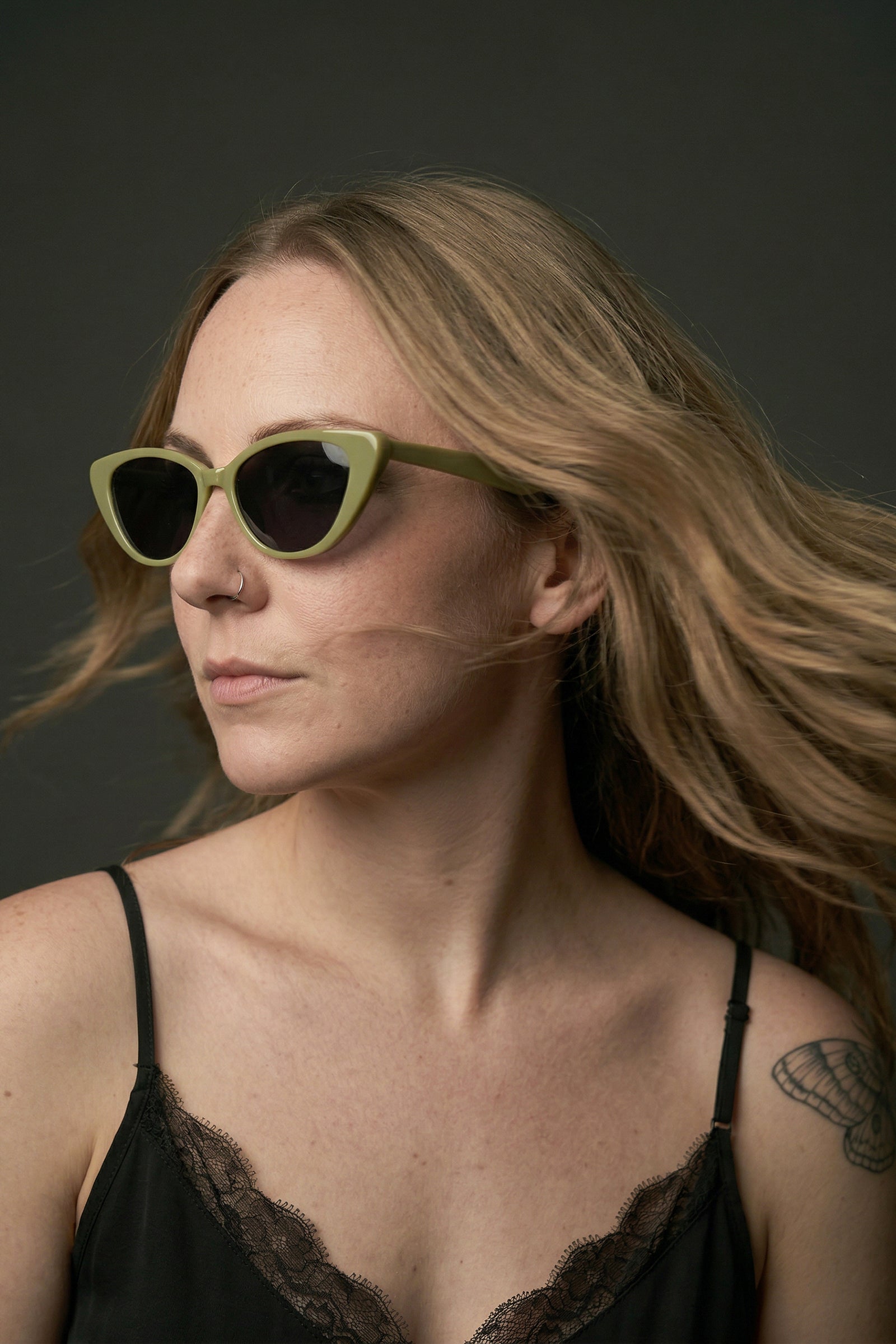 Model wearing olive cat eye sunglasses with boho styling styled with Nightbird Black Cami Top