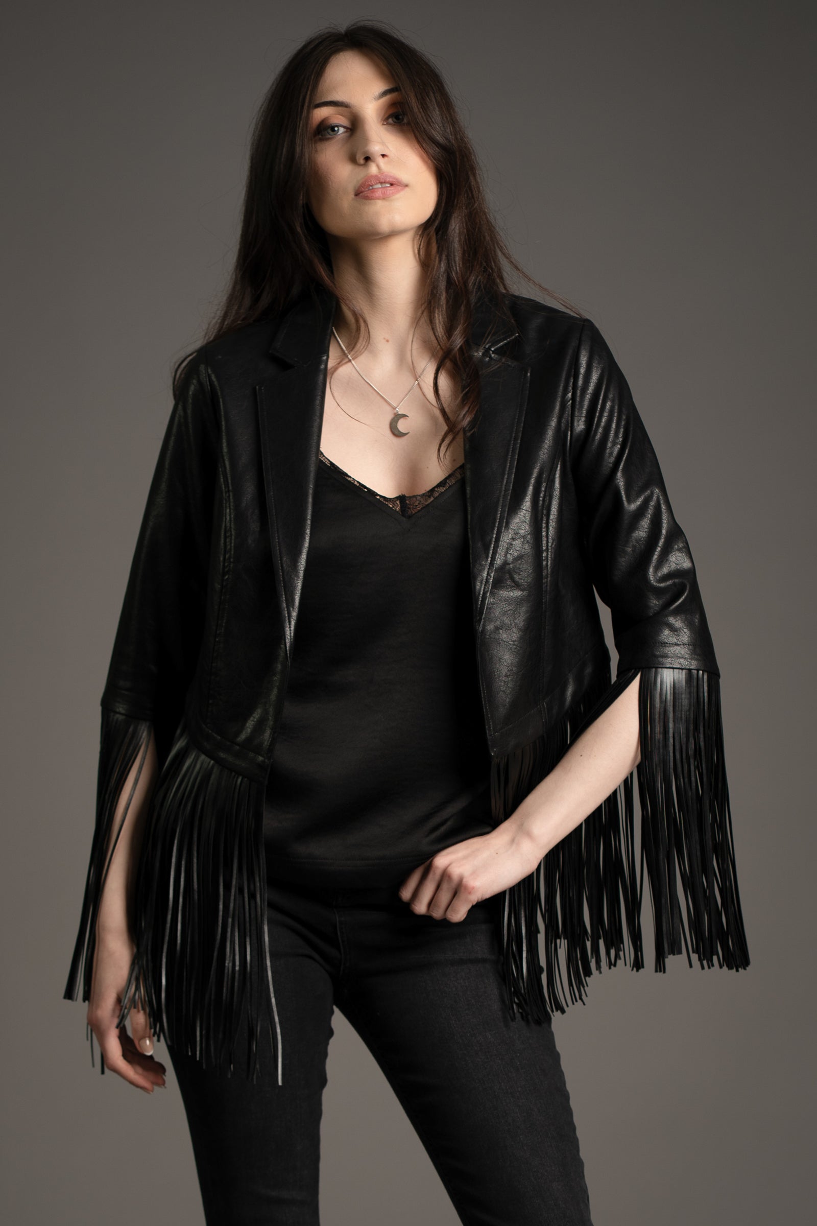 Andie models Little Lies Jagger fringed faux leather jacket in black, styled with slim black jeans