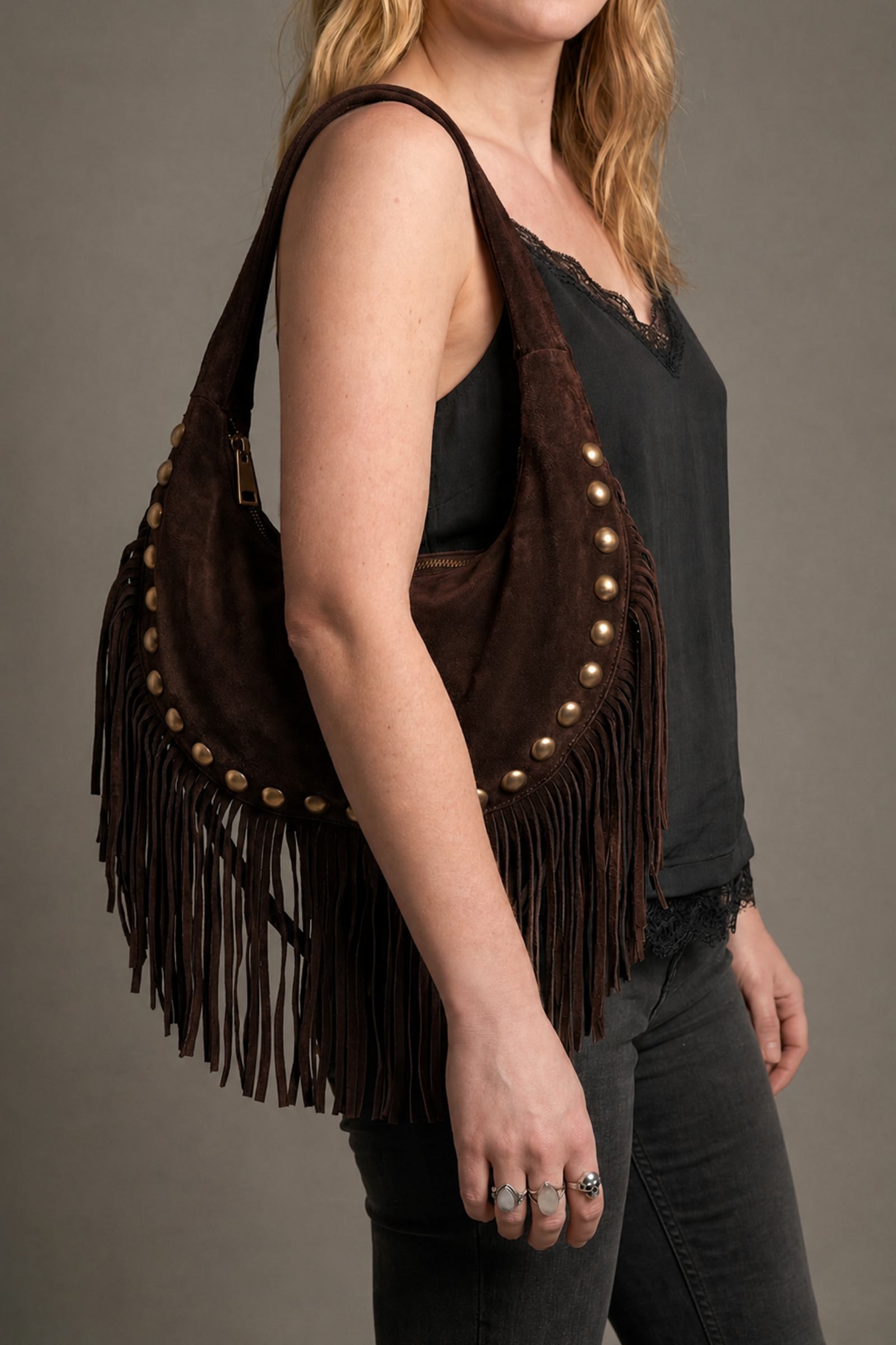 Little Lies Kate chocolate suede studded fringe bag – relaxed shoulder bag front view on model