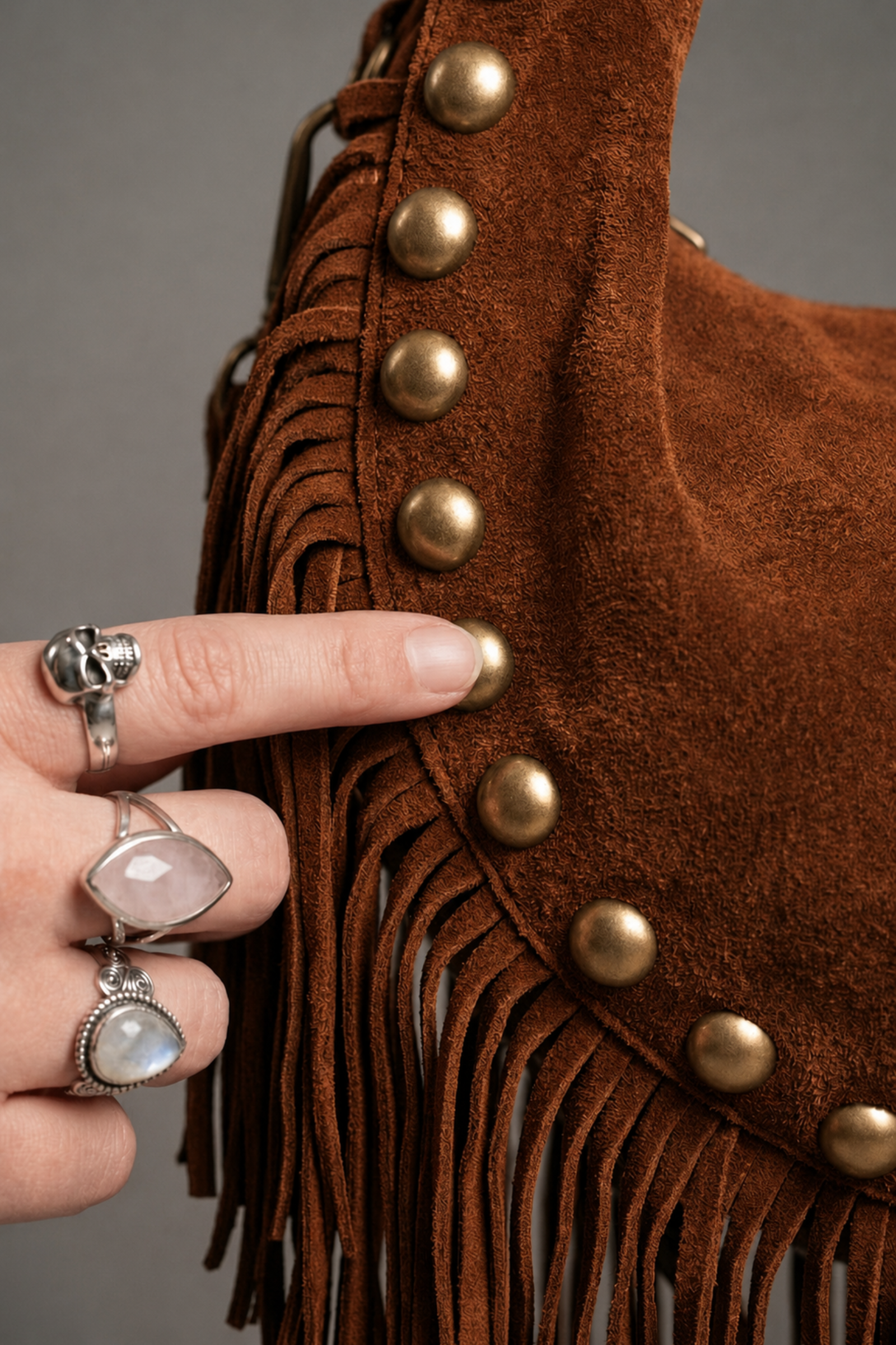 Little Lies Kate tan suede studded bag detail with fringe trim and gold stud accents close-up