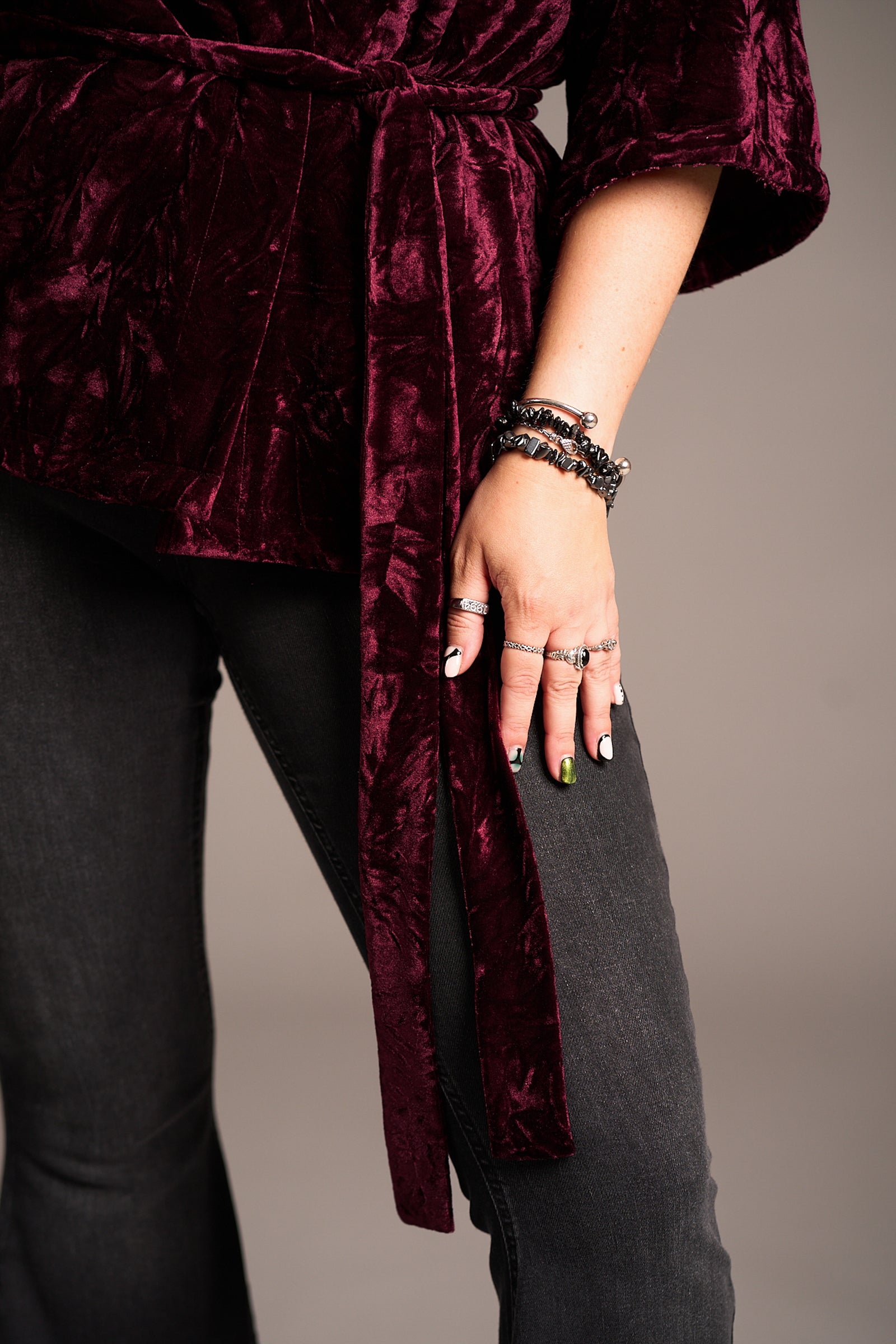 Close up of Erin showcasing the Lana Merlot Velvet Kimono in rich burgundy velvet with wrap front over denim jeans