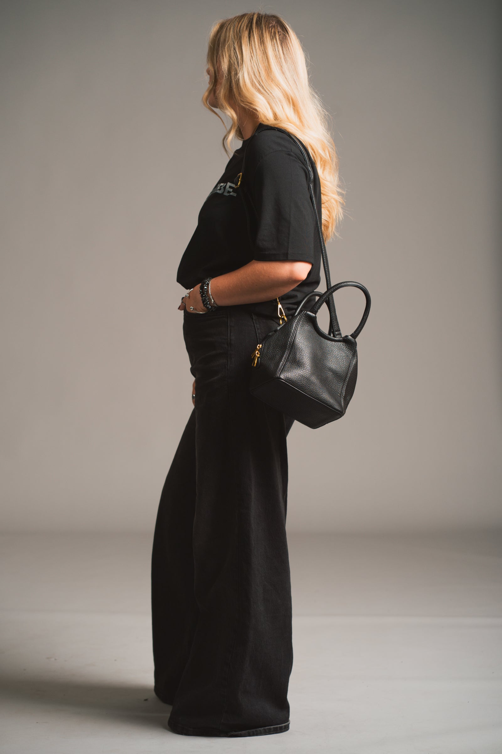 Model holding the Lana Faux Leather Black Mini Bag against a neutral background.