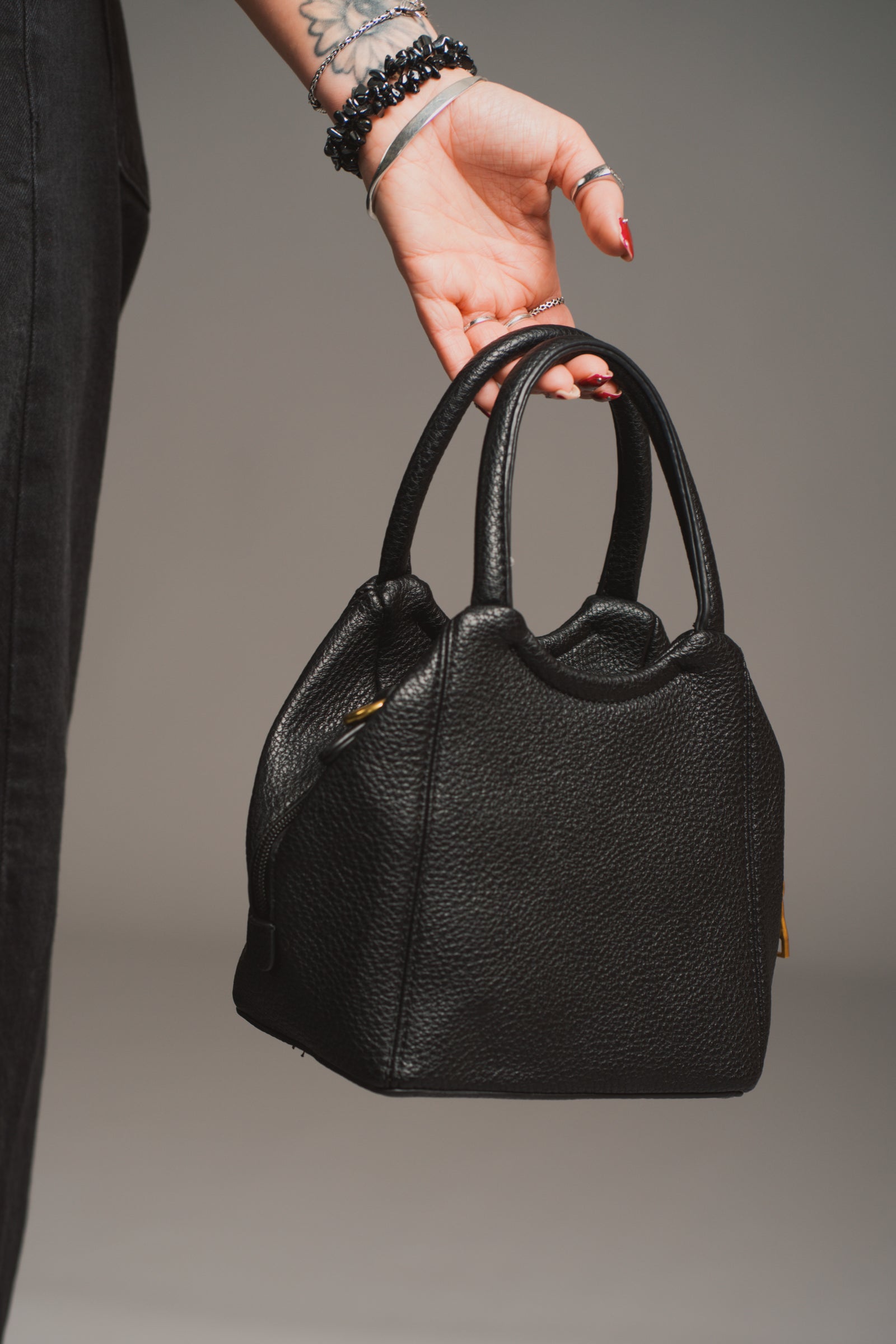 Model holding the Lana Faux Leather Black Mini Bag against a neutral background.