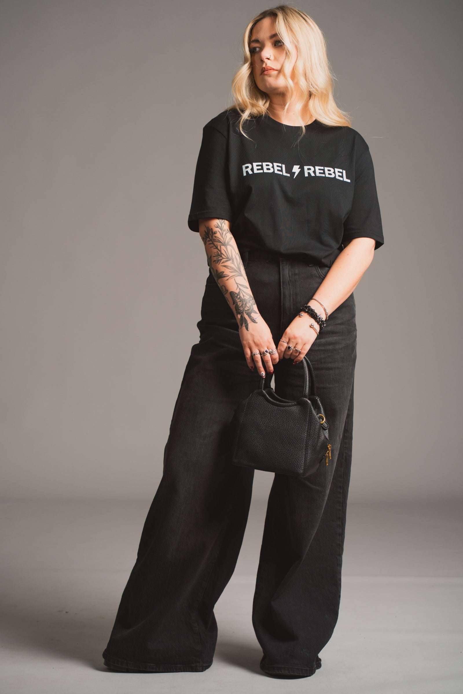Model holding the Lana Faux Leather Black Mini Bag against a neutral background.