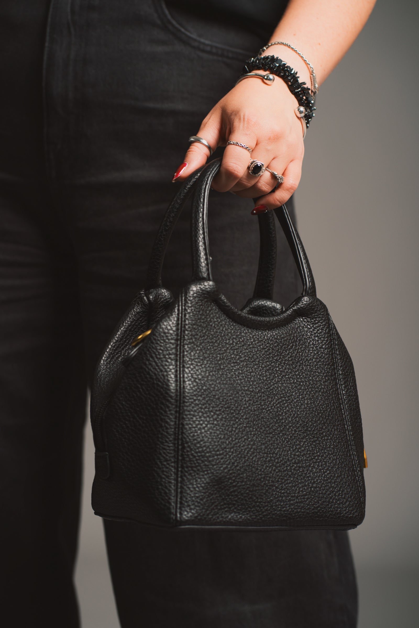 Model holding the Lana Faux Leather Black Mini Bag against a neutral background.