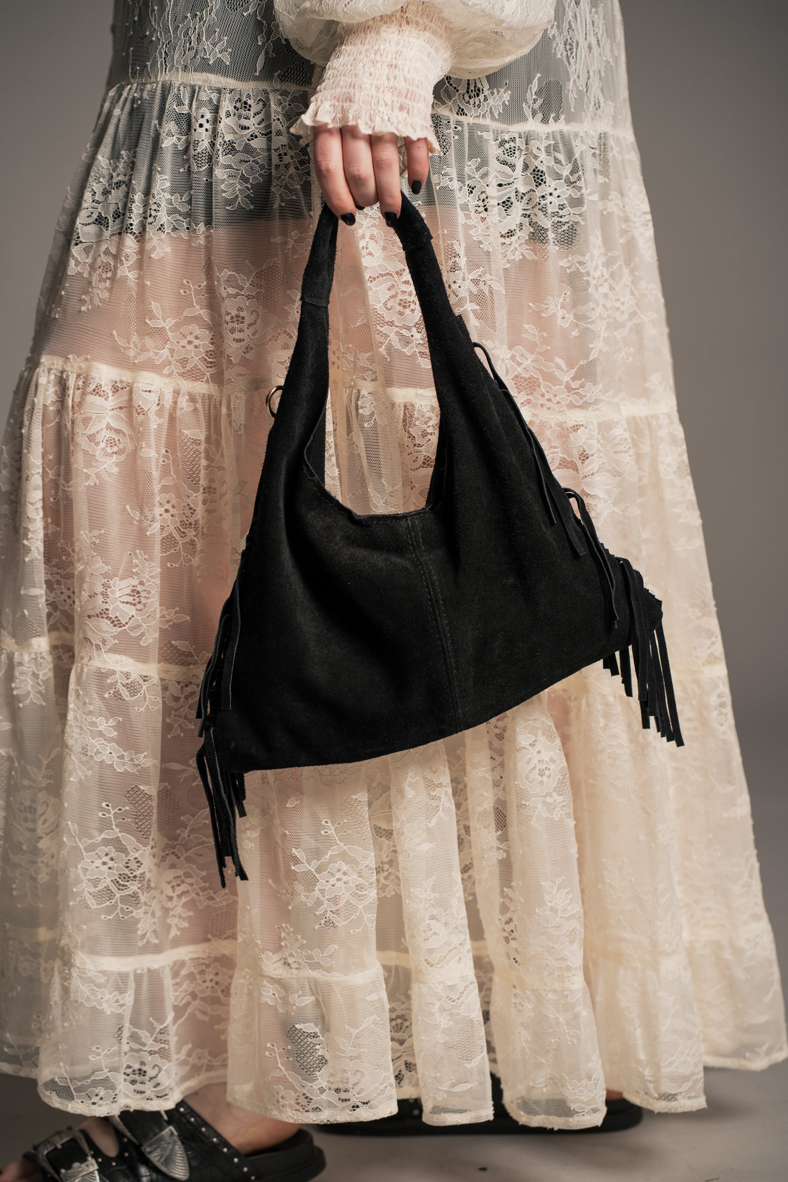 Little Lies Lila black genuine suede fringed grab bag, soft hobo style with tassel fringe, on‑body detail view