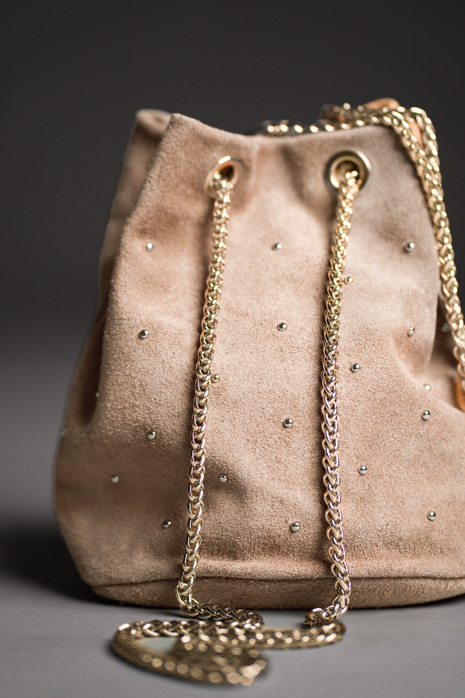 Lola Genuine Suede Studded Bucket Bag with a dark background