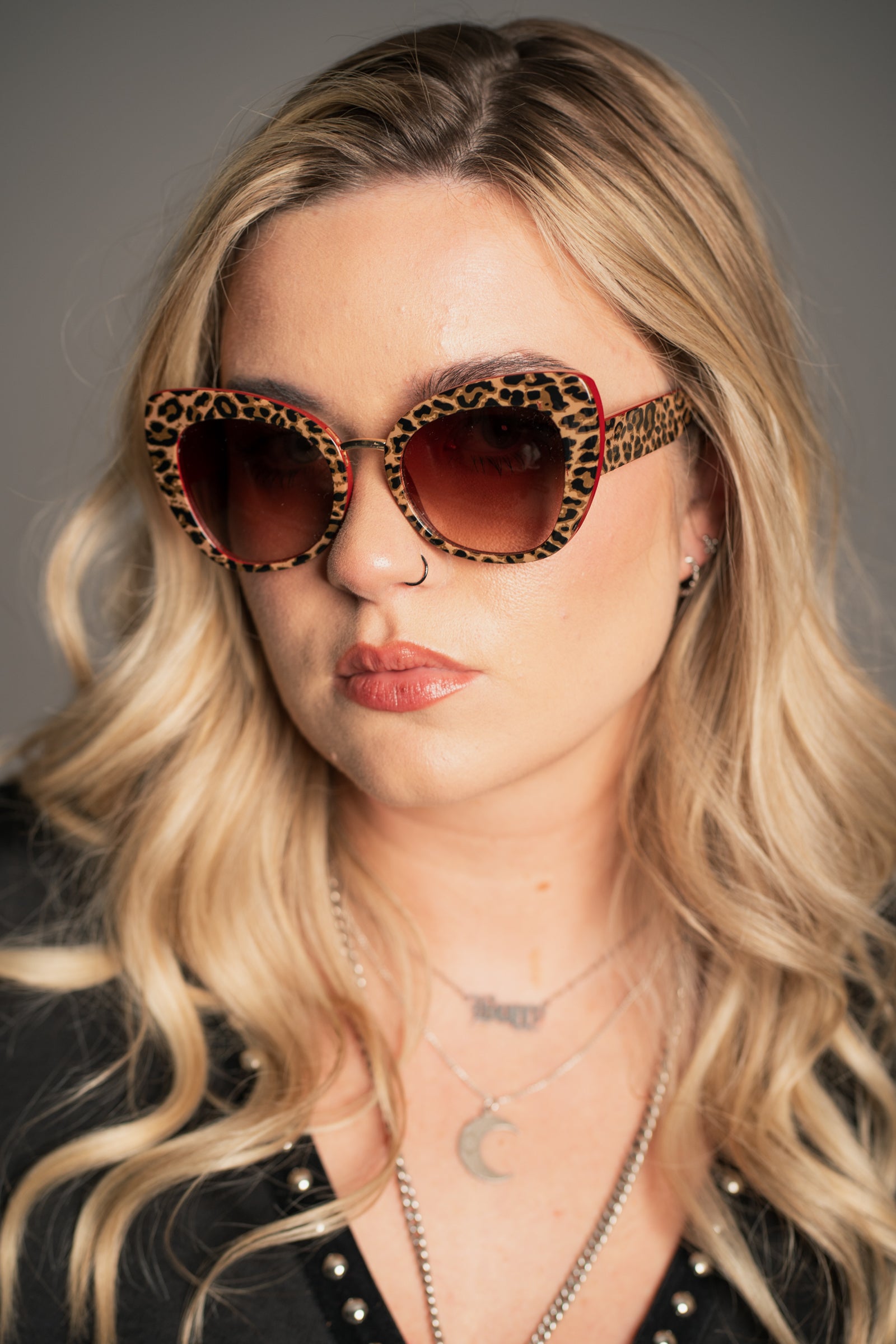 Little Lies Lola retro leopard print sunglasses with red frame detail and brown tinted lenses, oversized statement style, on‑model close‑up view