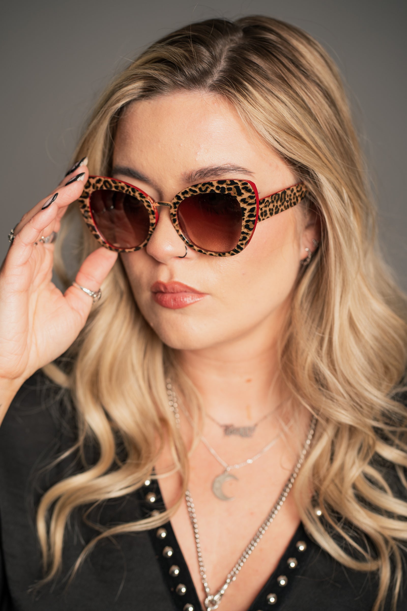 Little Lies Lola retro leopard print sunglasses with red frame detail and brown tinted lenses, oversized statement style, on‑model close‑up view