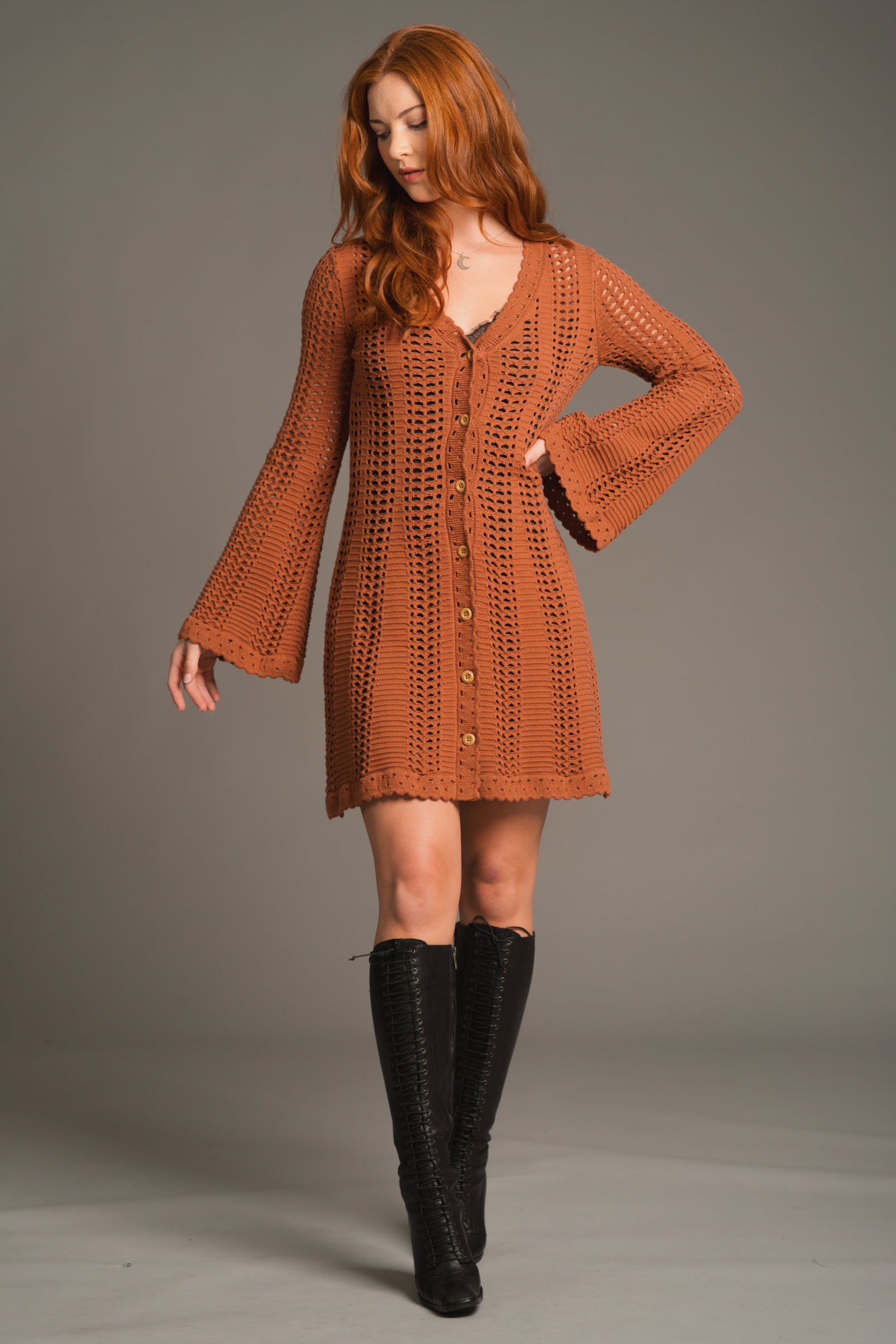 Full-length shot of Anna in Marianne Rust midi crochet style Knit Dress Styled with black knee high boots