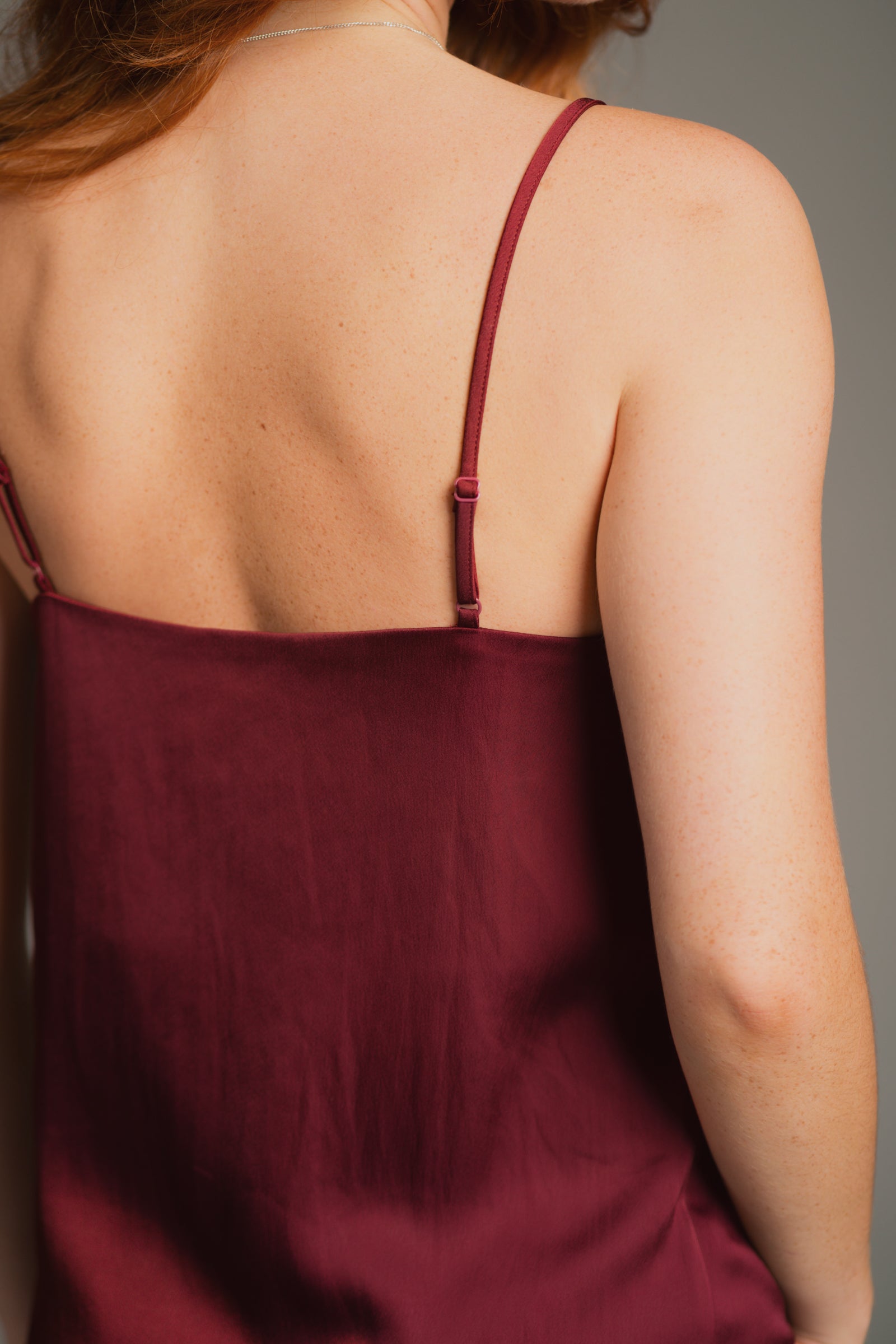 Back detailed view looking at the hammered plum satin, and strap detail.