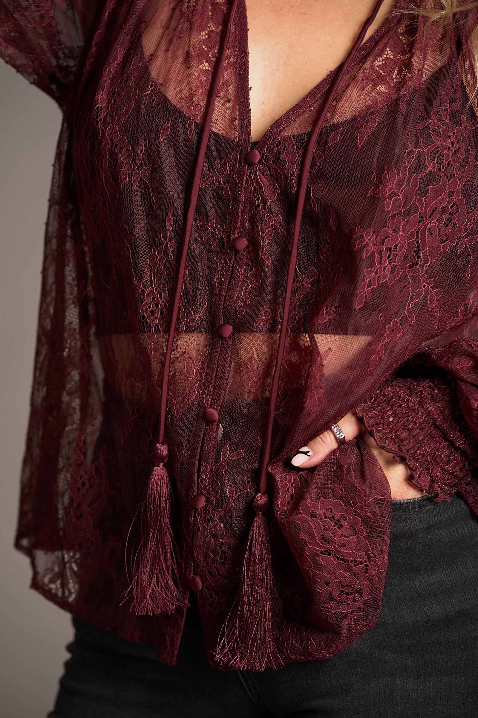 Close up of Rhiannon Burgundy Lace Smock Top, fabric shot showing tassel tie and button detail