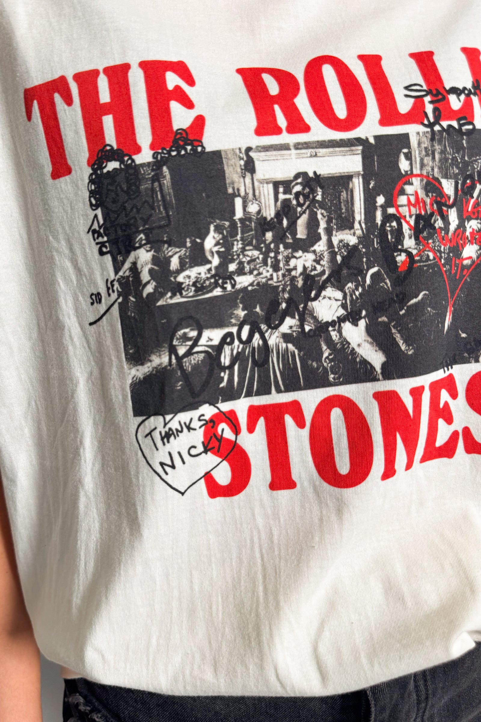 Side detail of Rolling Stones Graffiti band tee showing monochrome collage artwork and graffiti elements