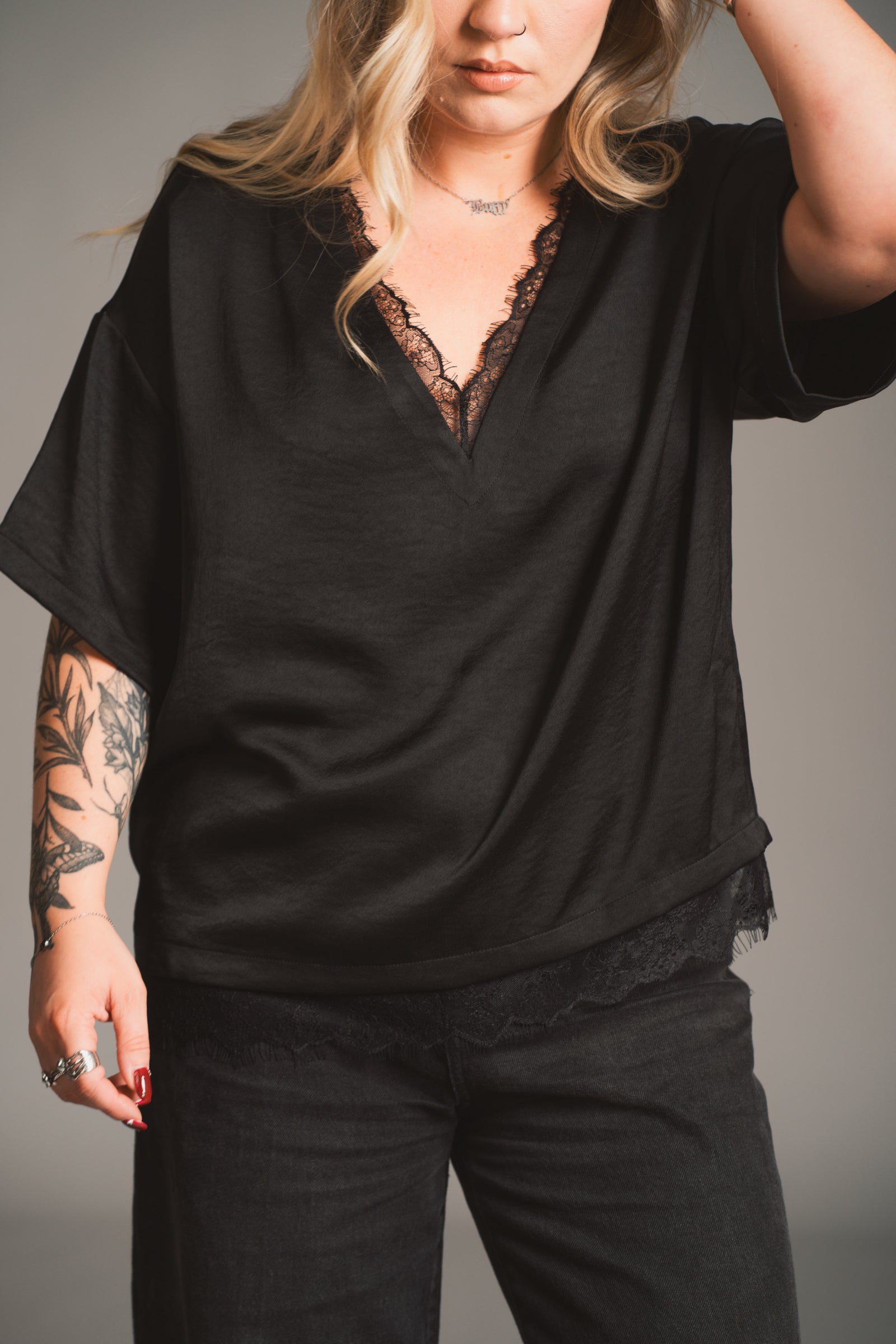 Model wearing the Roxy Lace trim Satin black tee with lace trim against a neutral background