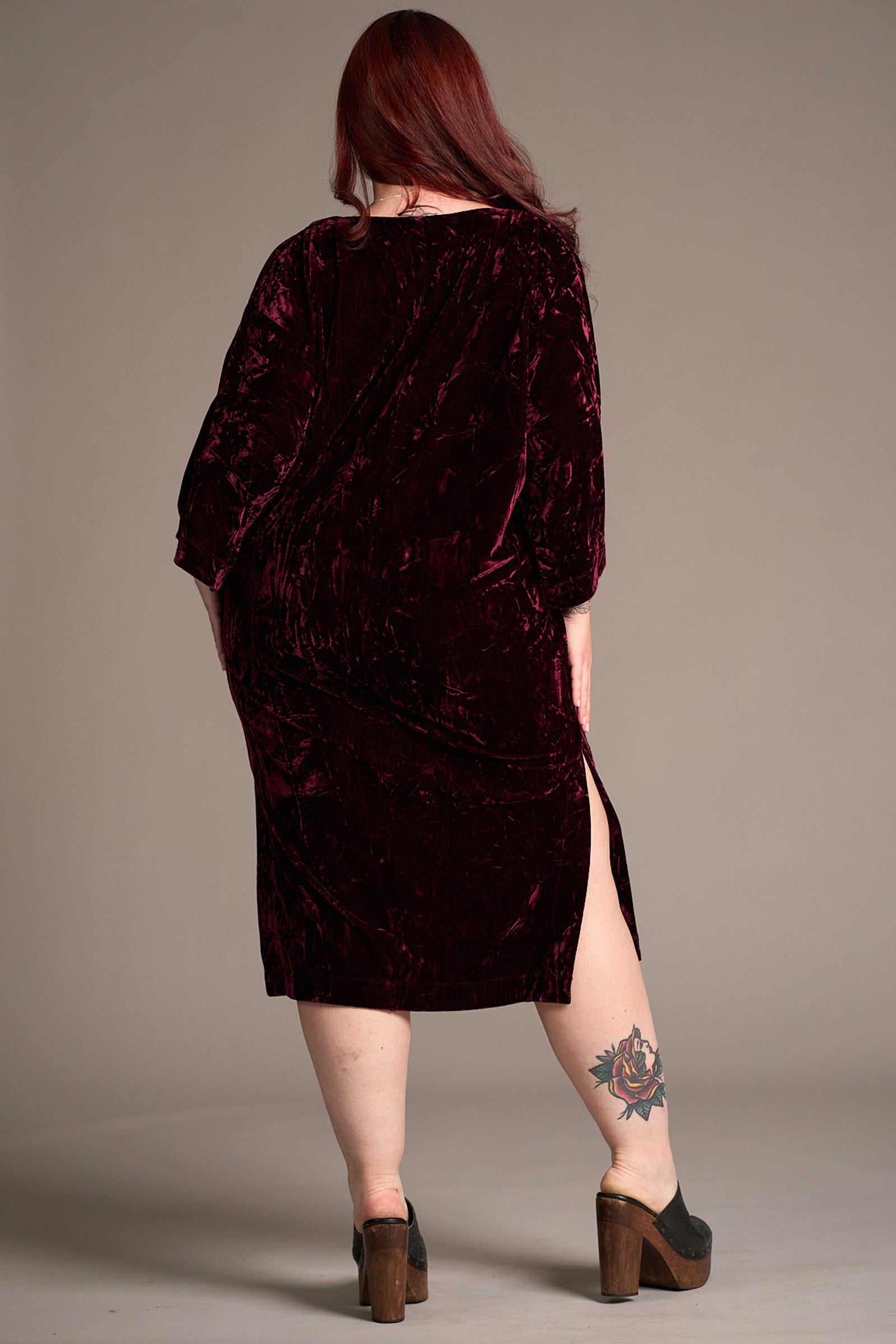 Taylor showing the back of the Rumours Merlot Velvet Midi Dress, side split detail. Stevie Nicks inspired styling studio