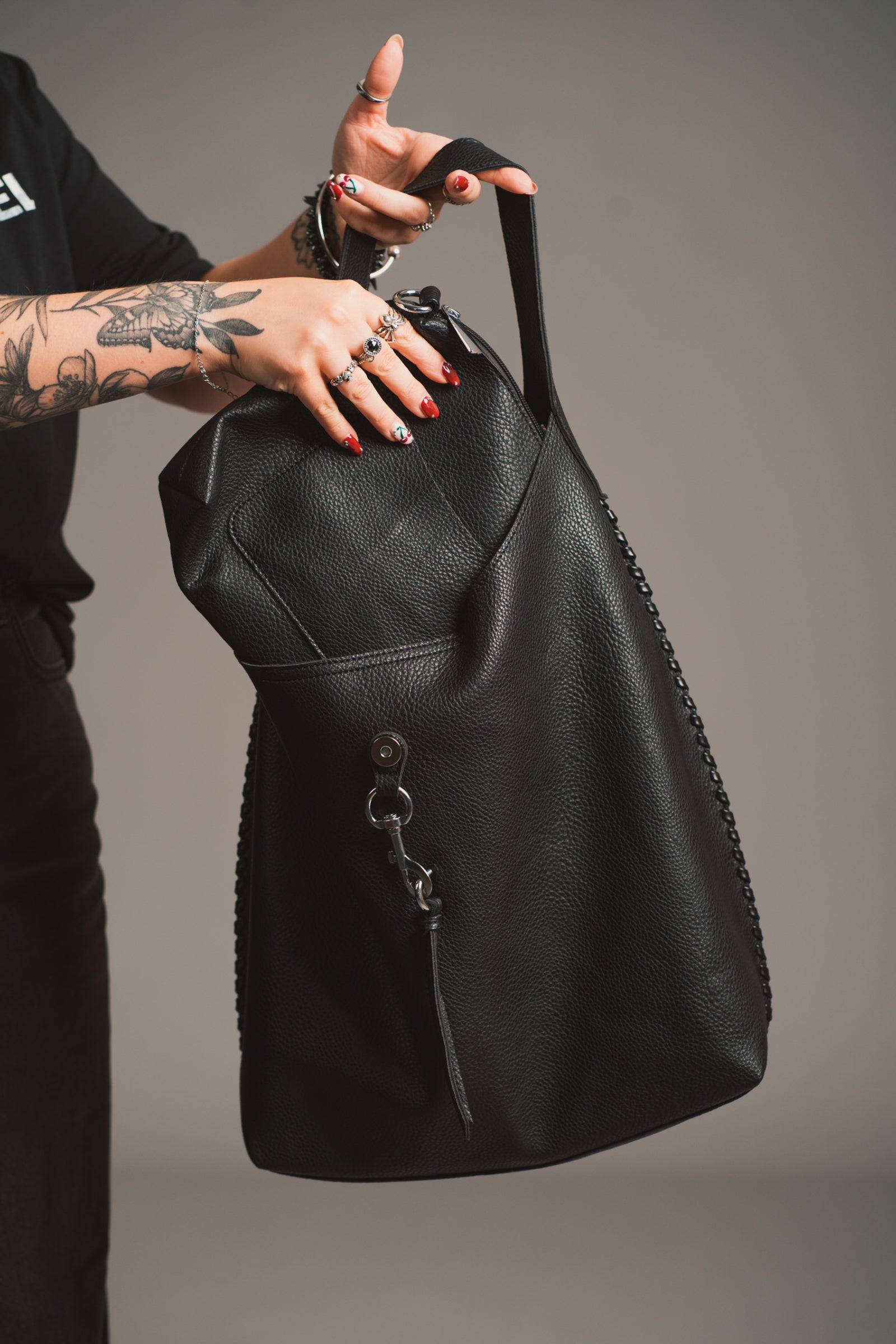 Model holding the Sadie Boho Hobo Faux Leather black bag insert, in studio shot.
