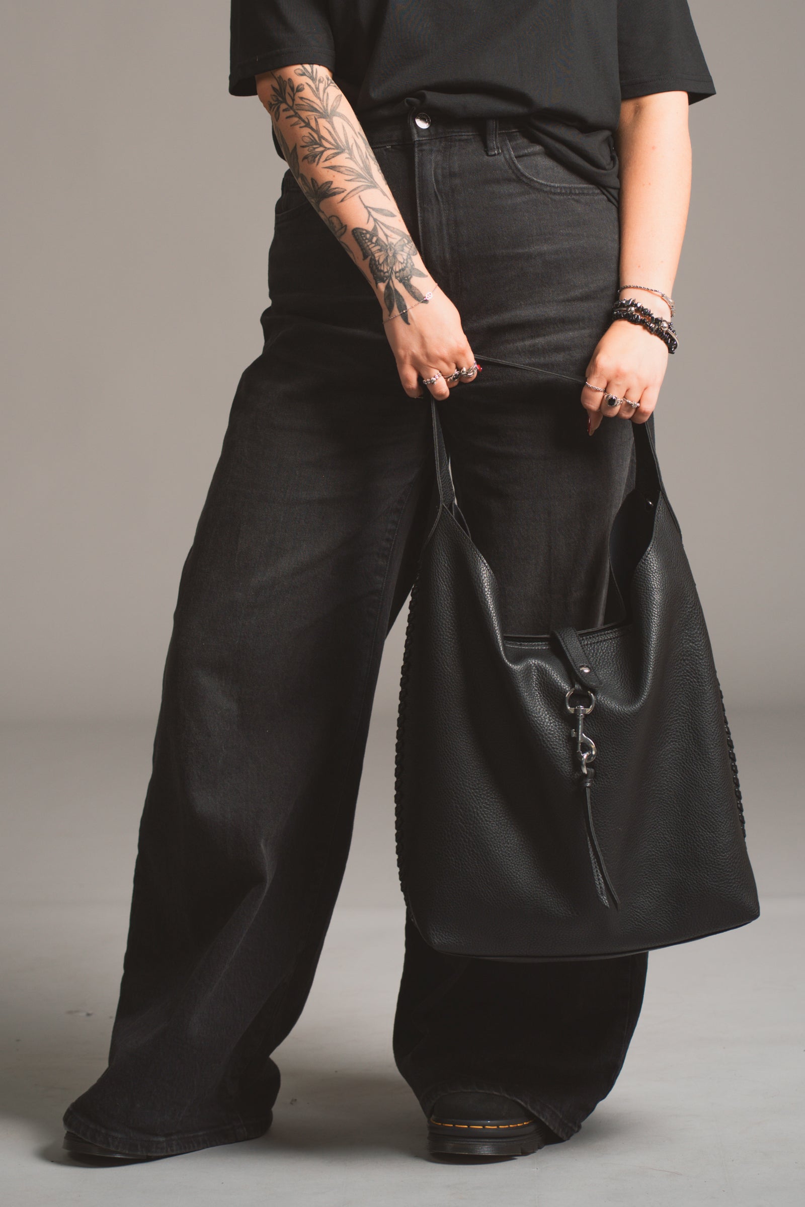 Model holding the Sadie Boho Hobo Faux Leather black bag, in studio shot.