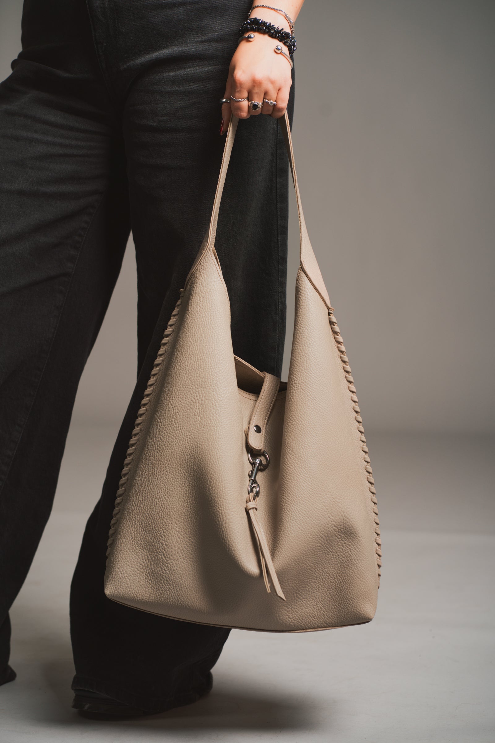 Sadie Taupe Faux Leather Hobo handbag held by a model against a neutral background
