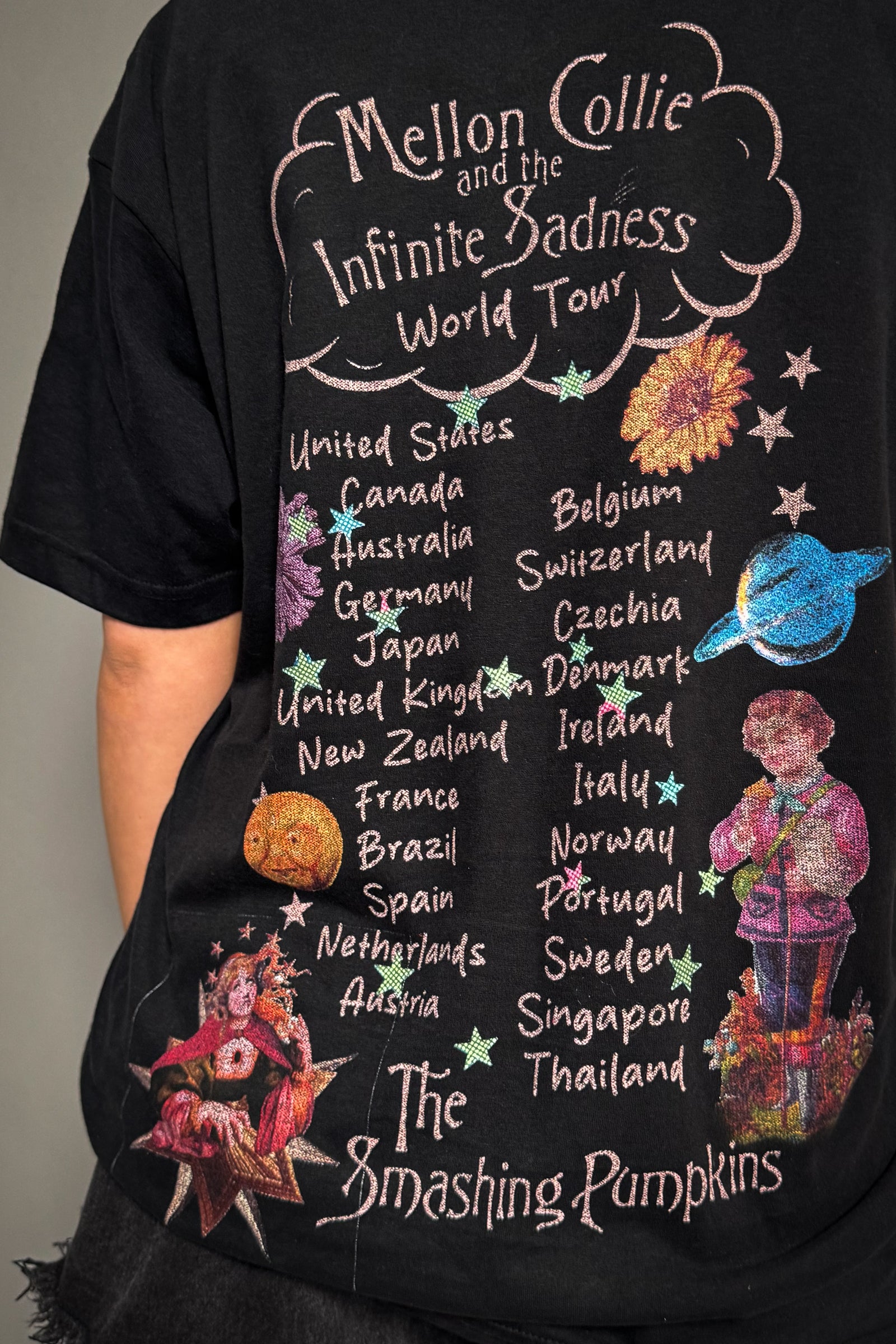Close-up of Little Lies Smashing Pumpkins band tee showing colourful celestial graphic with stars, planets and vintage-style tour print