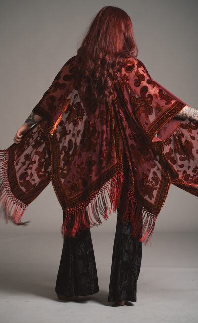 Taylor wearing the Stevie Plum Floral Fringed Devore Kimono paired with Black velvet flares. 