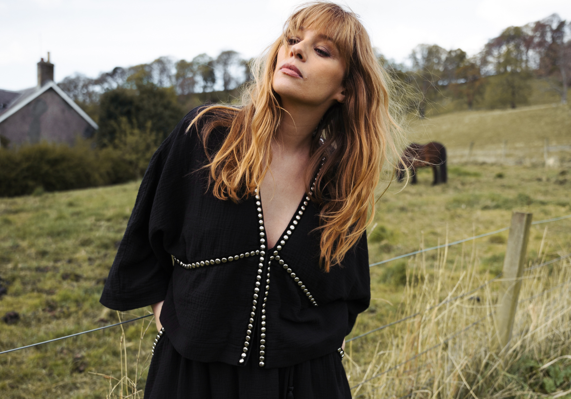 Model Tinna wearing in a festival field wearing the rock n roll Kravit Black Studded Top.