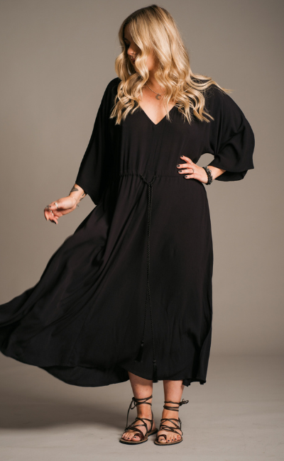 Model Erin in against the neutral studio backdrop wearing the Bohemian Blackbird Black tie waist Midi Dress. 