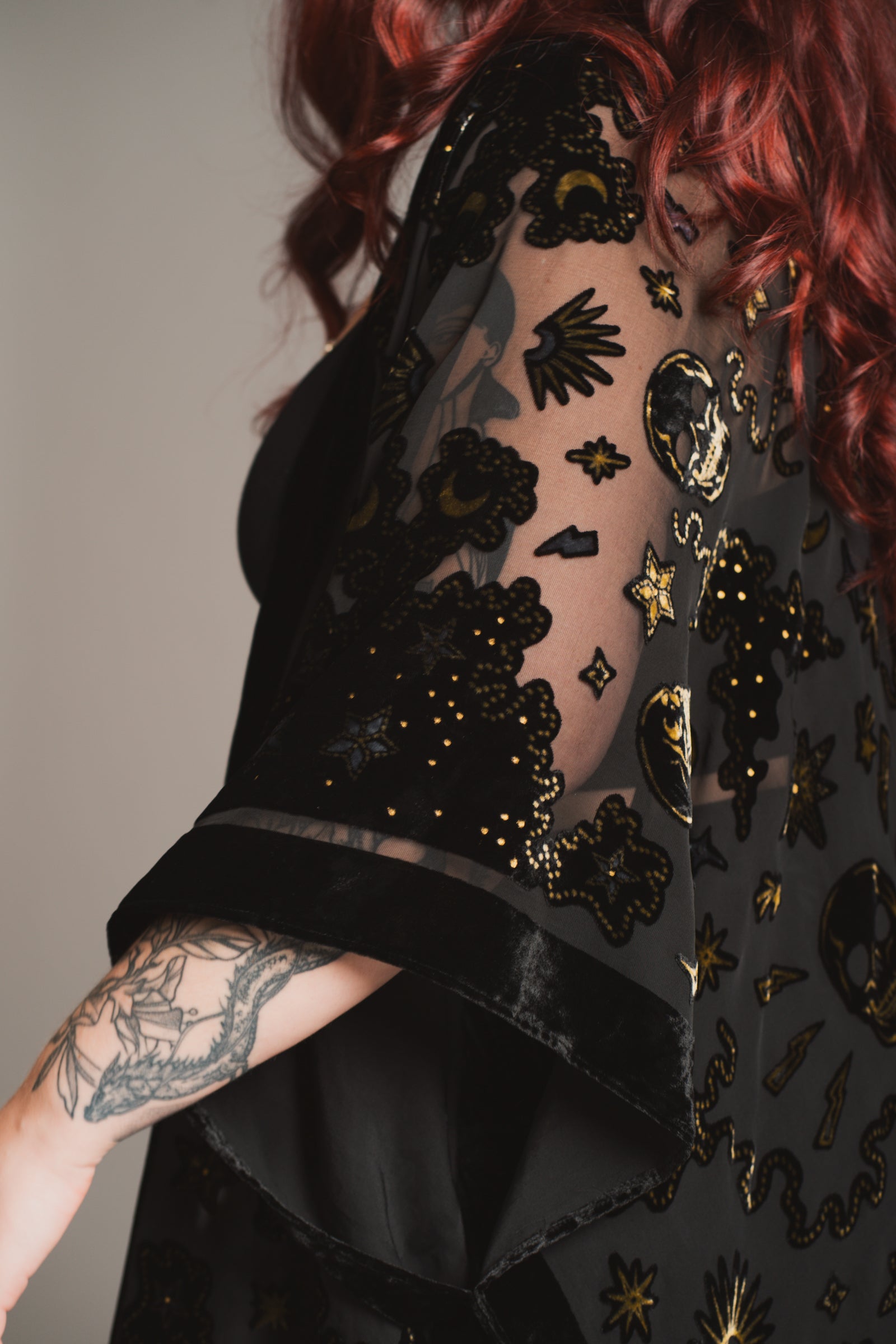 Little Lies Suzi Skull devore kimono in black, close-up showing intricate skull and celestial pattern with gold accents on sheer fabric and velvet trim