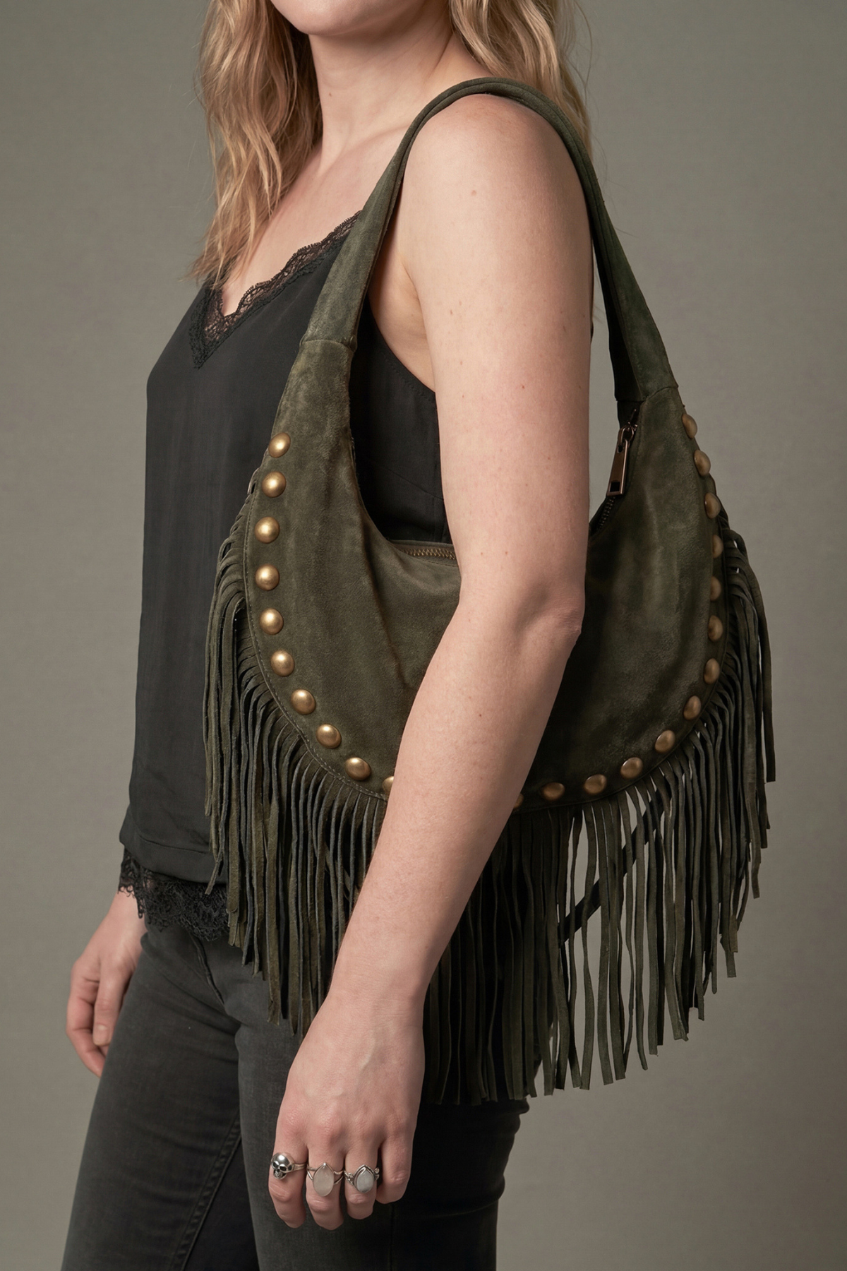 Model wearing Little Lies Kate khaki genuine suede studded shoulder bag with fringe detail