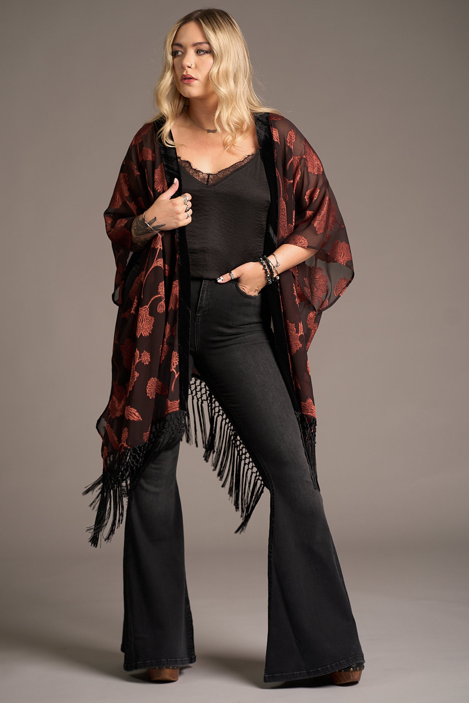 Erin wears Venus Fringed Kimono with black sheer fabric, red floral print, and fringe hem. Stevie Nicks inspired styling studio
