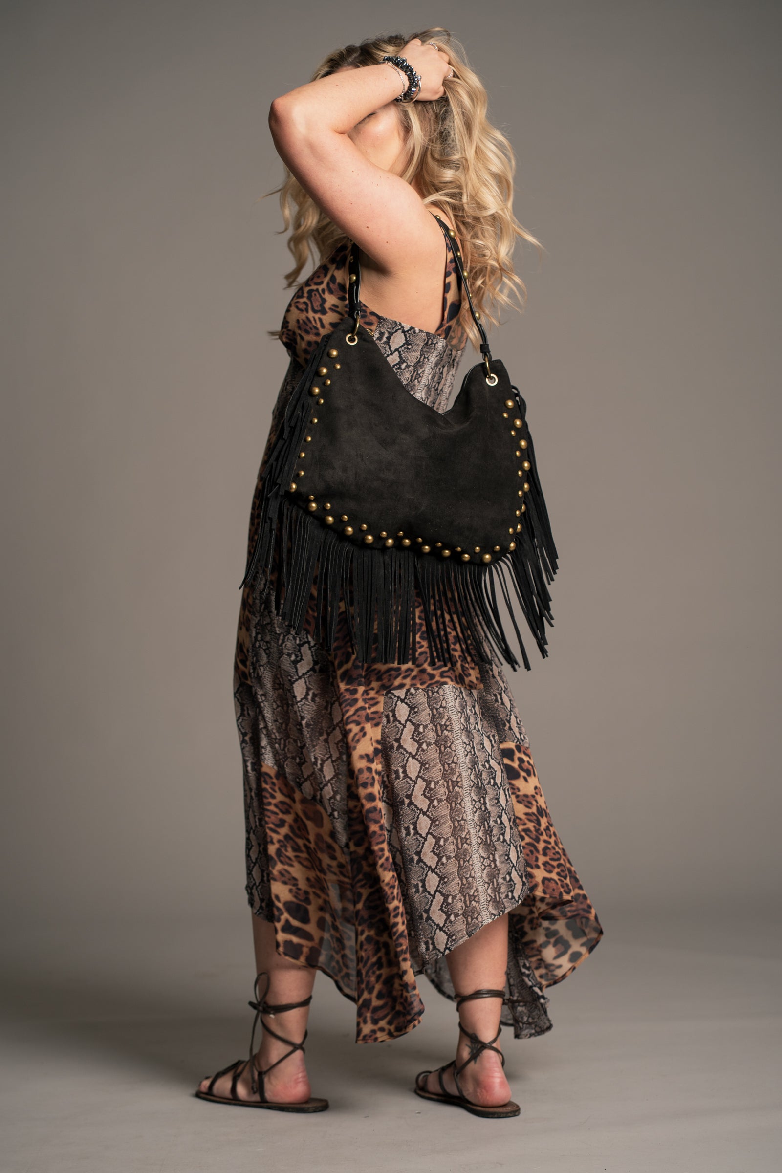 Model wearing Little Lies Willow Slouchy Black Faux Suede Studded Bag styled with the Zadie Animal Handkerchief Dress