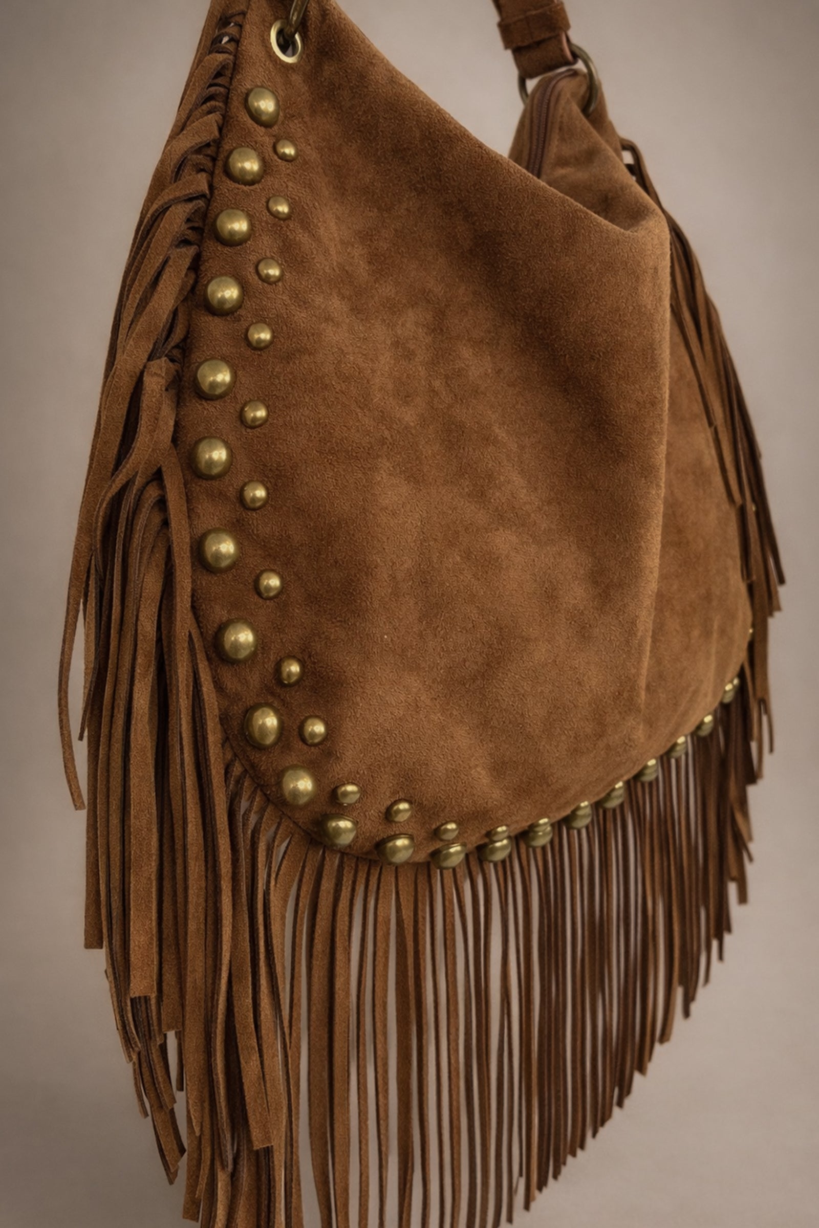 Little Lies Willow Slouchy tan faux suede bag with fringe and rivet detail in studio setting.