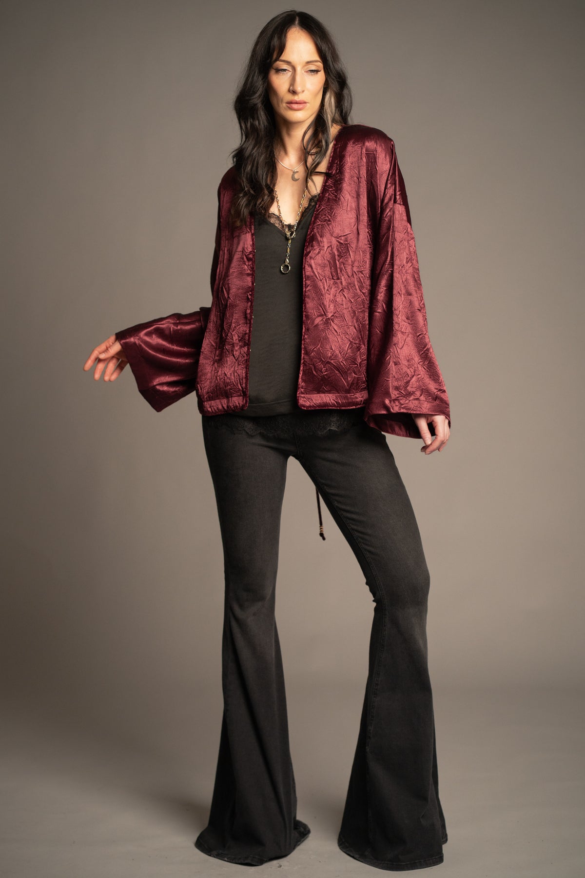 Celeste wine kimono top worn open featuring a deep V-neckline, velvet piping detail, relaxed fit and flowing kimono sleeves, styled with Hendrix Denim flares.