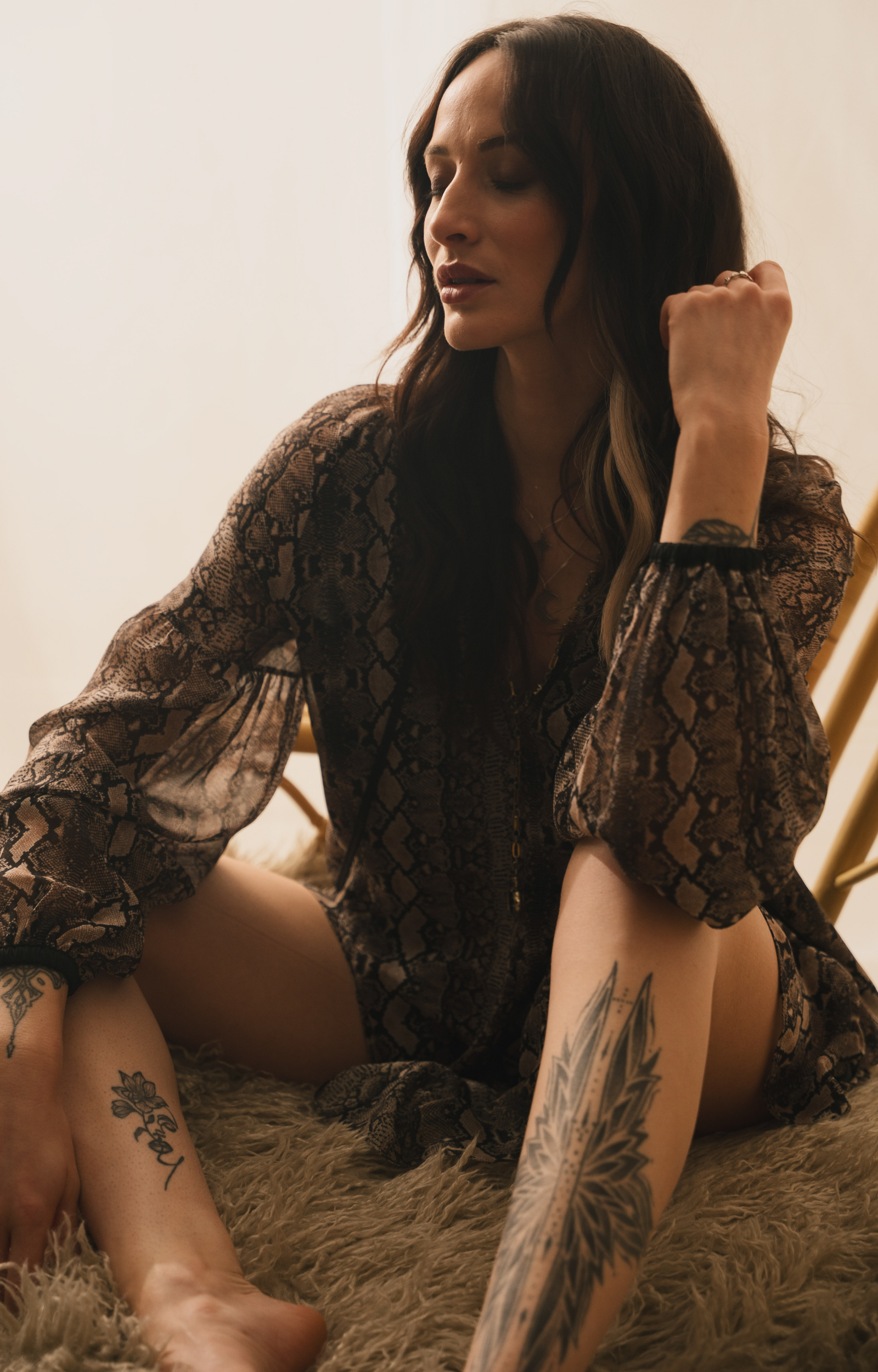 Model wearing the Little Lies Seeker Snake Mini Dress featuring a flowing snake‑print fabric, deep V‑neckline, and long voluminous sleeves.