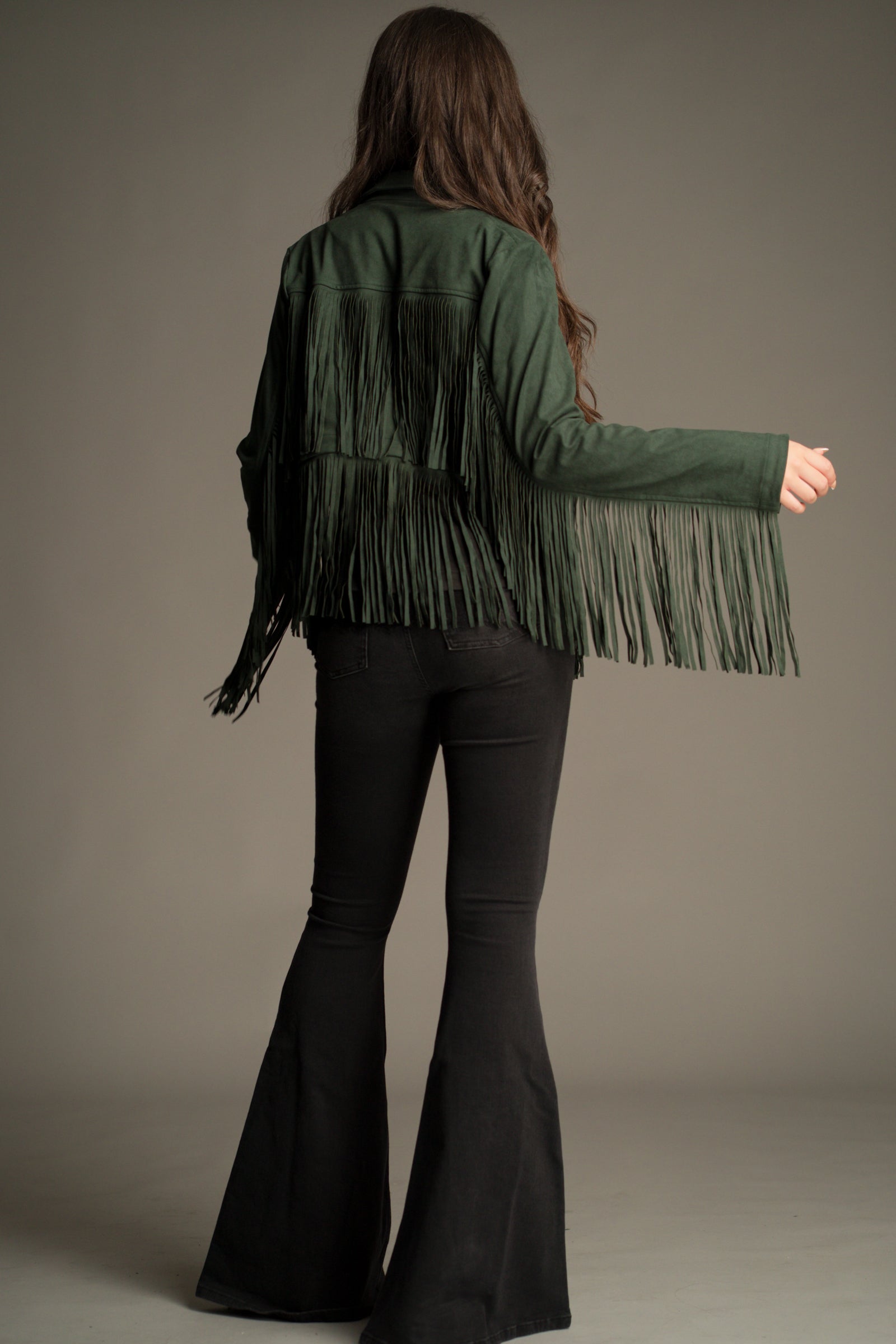 Full length back view of the Ivy Emerald Green Fringed Faux Suede Jacket showing back and sleeve fringe details.