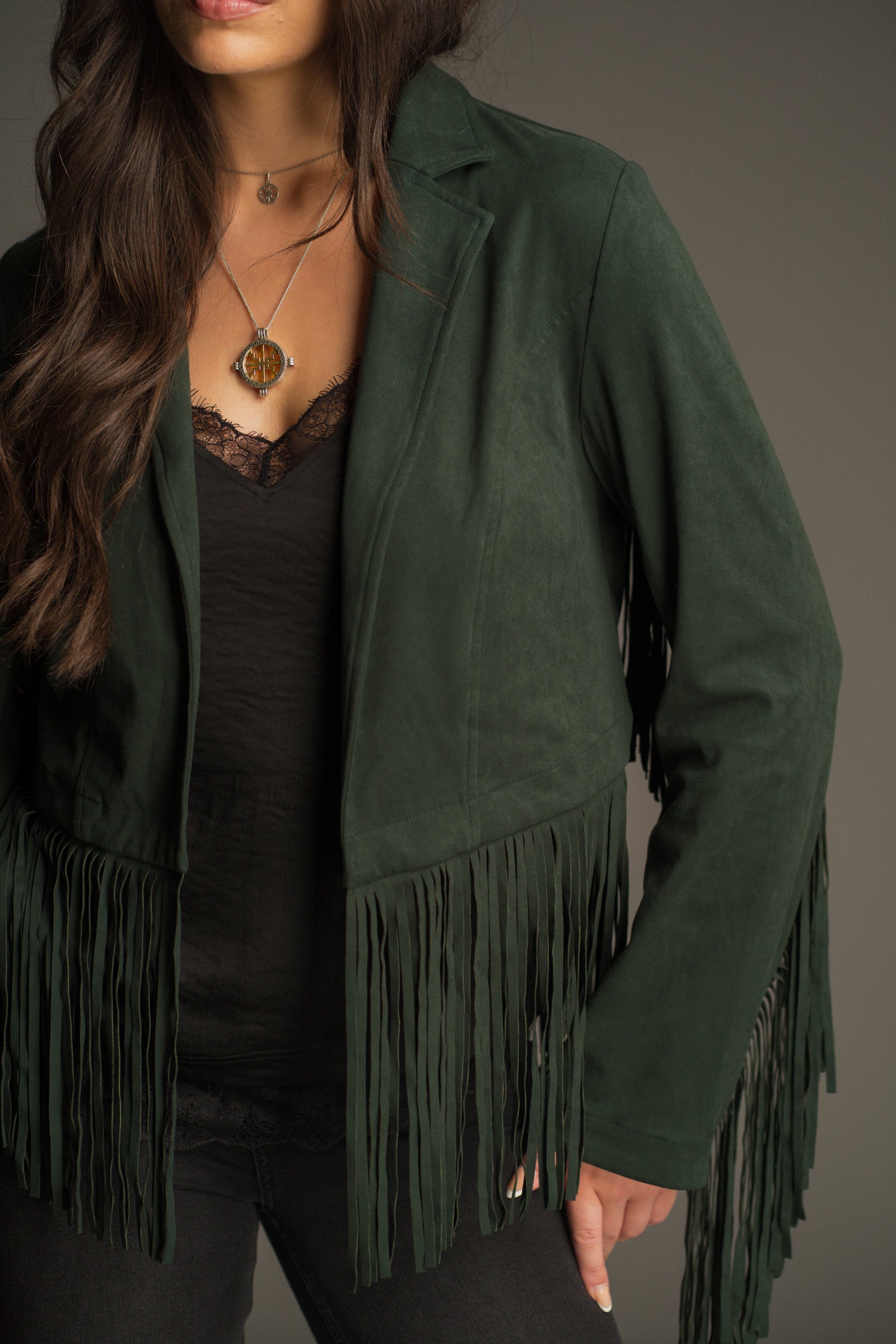 Front view of the Ivy Emerald Green Fringed Faux Suede Jacket showing slim lapel and hem fringe detail.