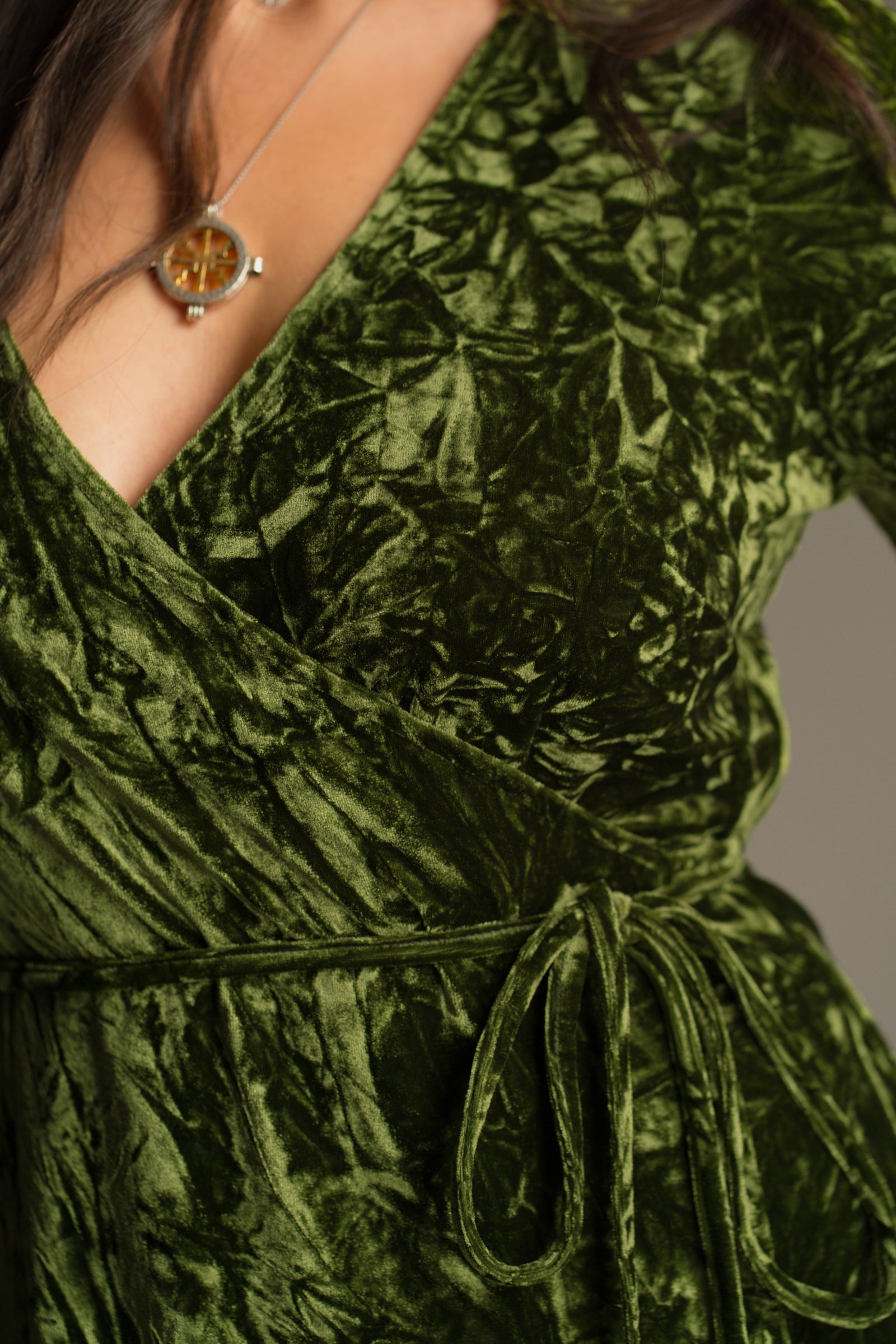 Waist tie detail view of the Jaded Olive Crushed Velvet Wrap Mini Dress showing wrap front and velvet texture.