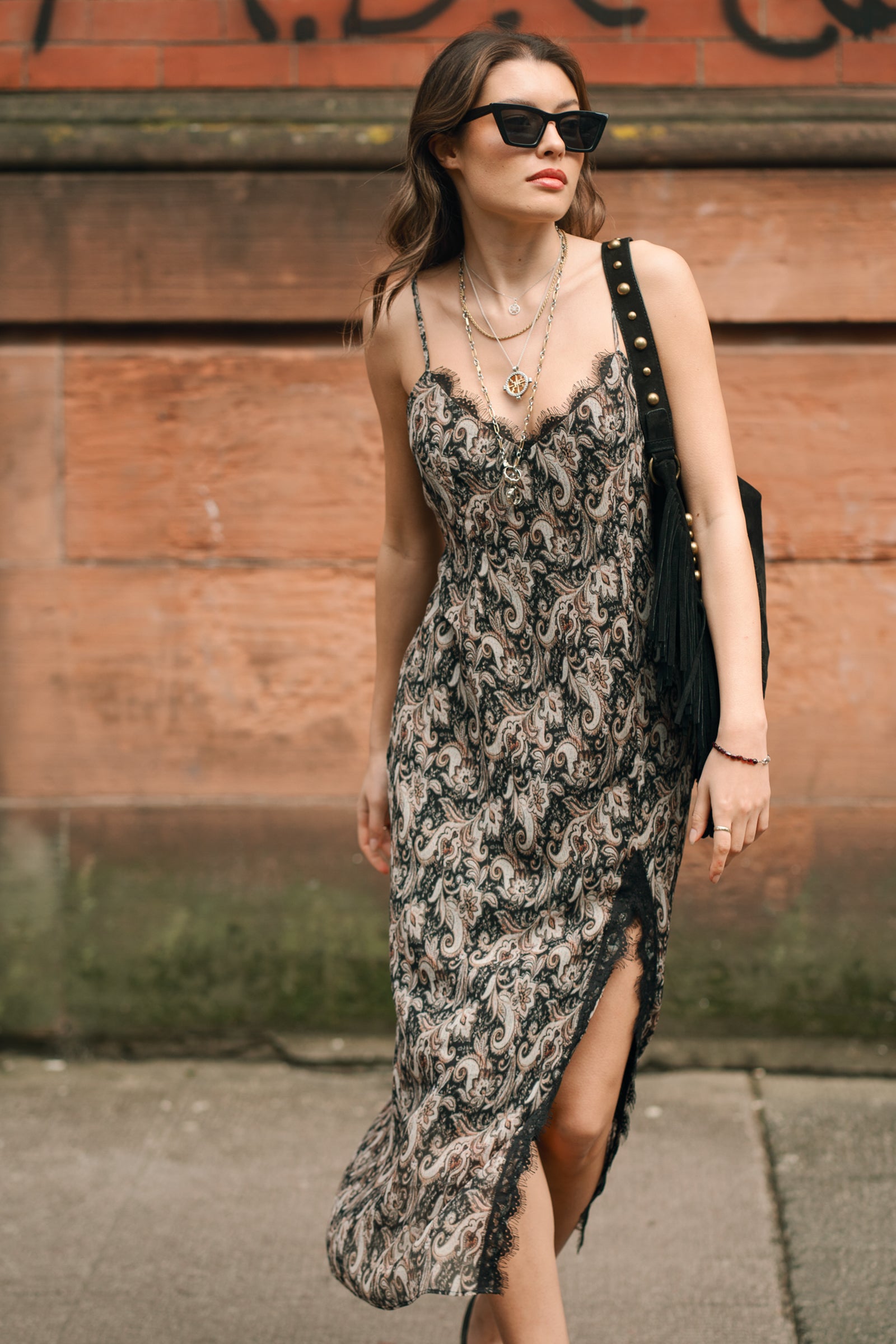 Close-up of Little Lies Eleanor Paisley Slip Dress lace trim styled with Willow Black Fringed studded bag, Glasgow street style.