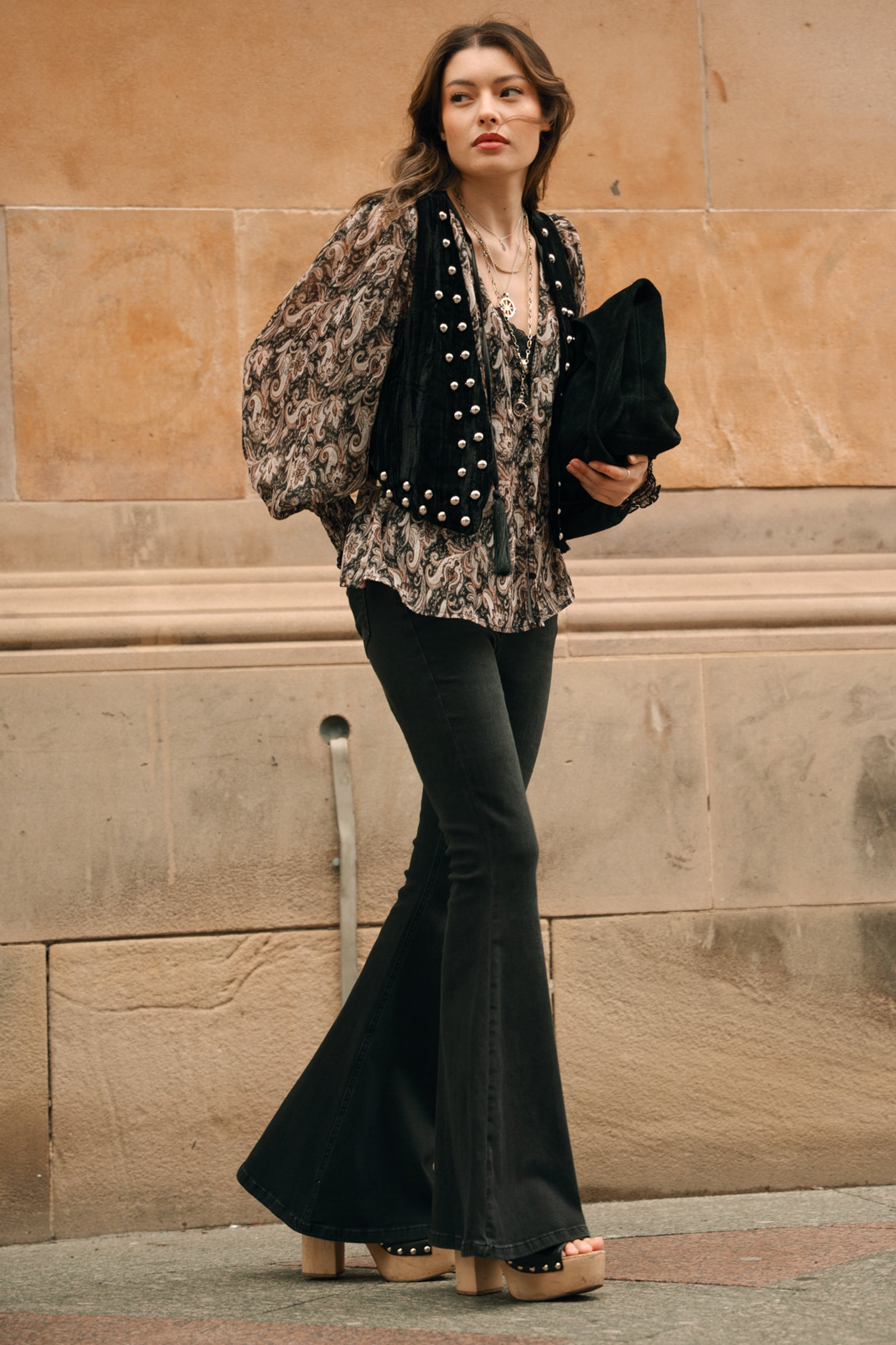 Bronwyn wearing Little Lies Lennon black studded velvet waistcoat styles with Hendrix Denim flares.