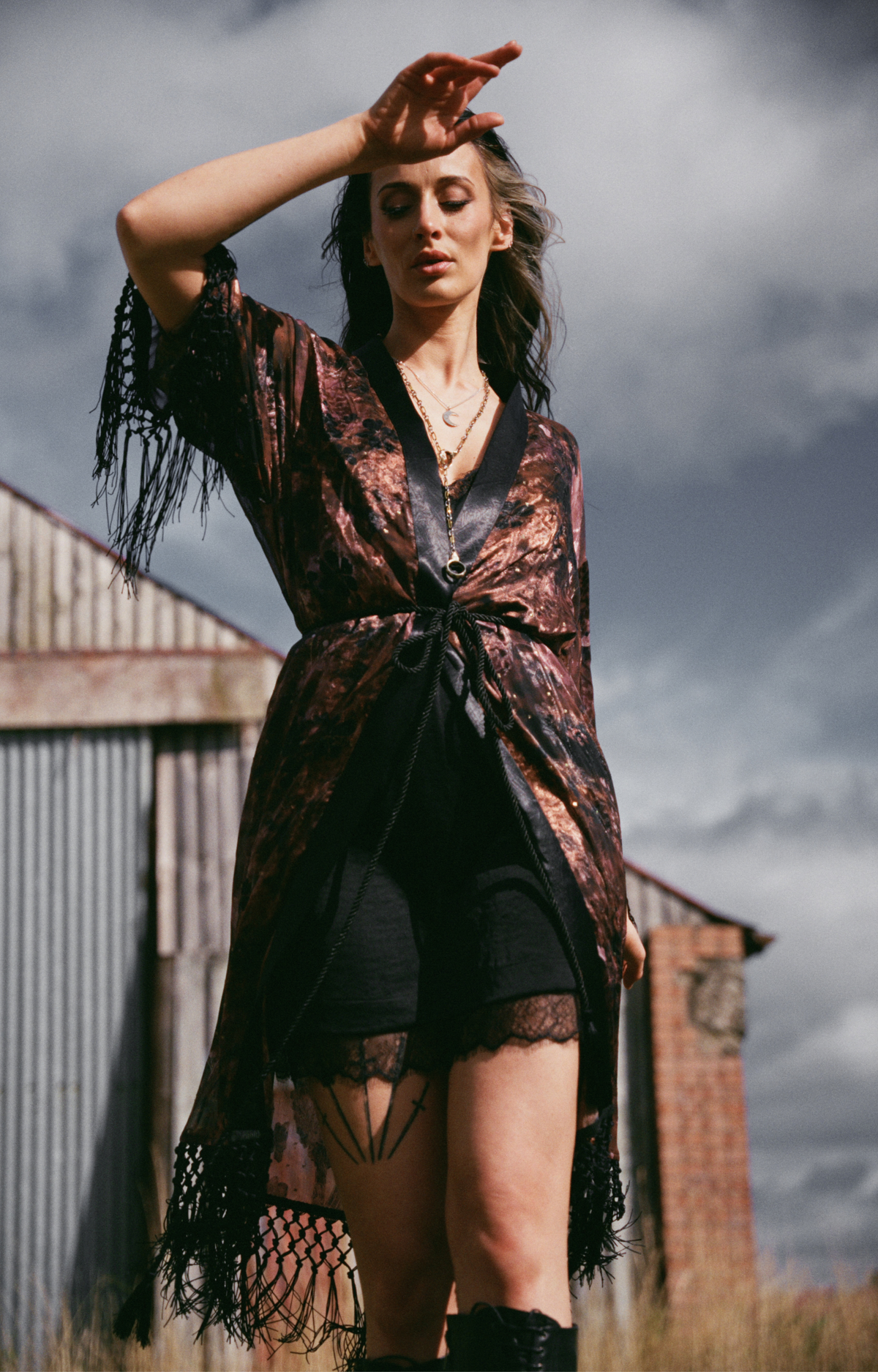 Little Lies Practical Magic fringed kimono in a burgundy celestial print layered over a black lace trim mini dress