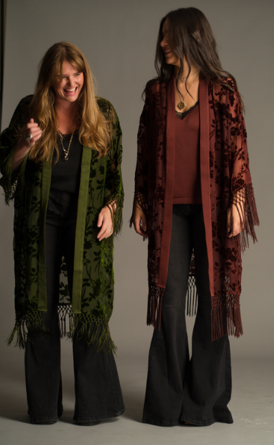 On set Autumn campaign, showcasing Little Lies Dakota olive and rust devore kimonos with sheer floral velvet detailing and tassel trim in studio setting