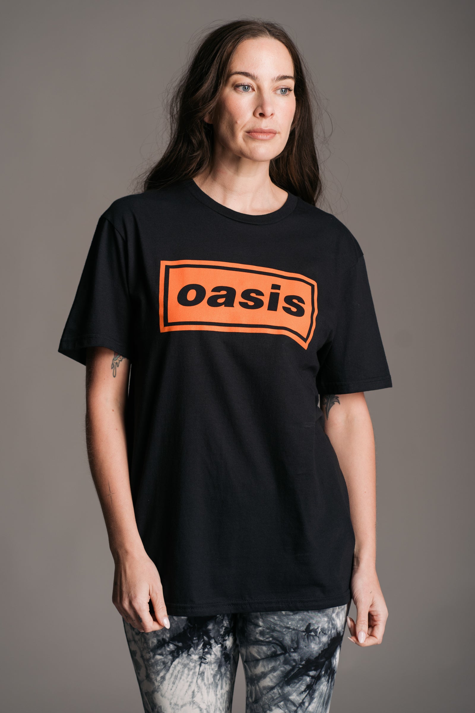 Close-up of Oasis Access All Areas pass-style graphic in black and orange on black tee