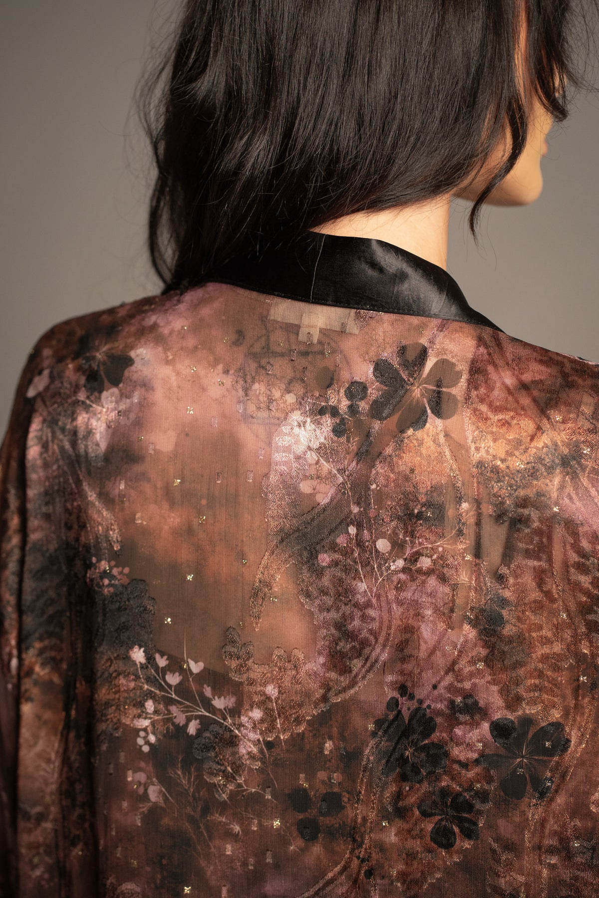 Close-up of Practical Magic kimono showcasing vintage-inspired floral print, sheer fabric and black satin trim
