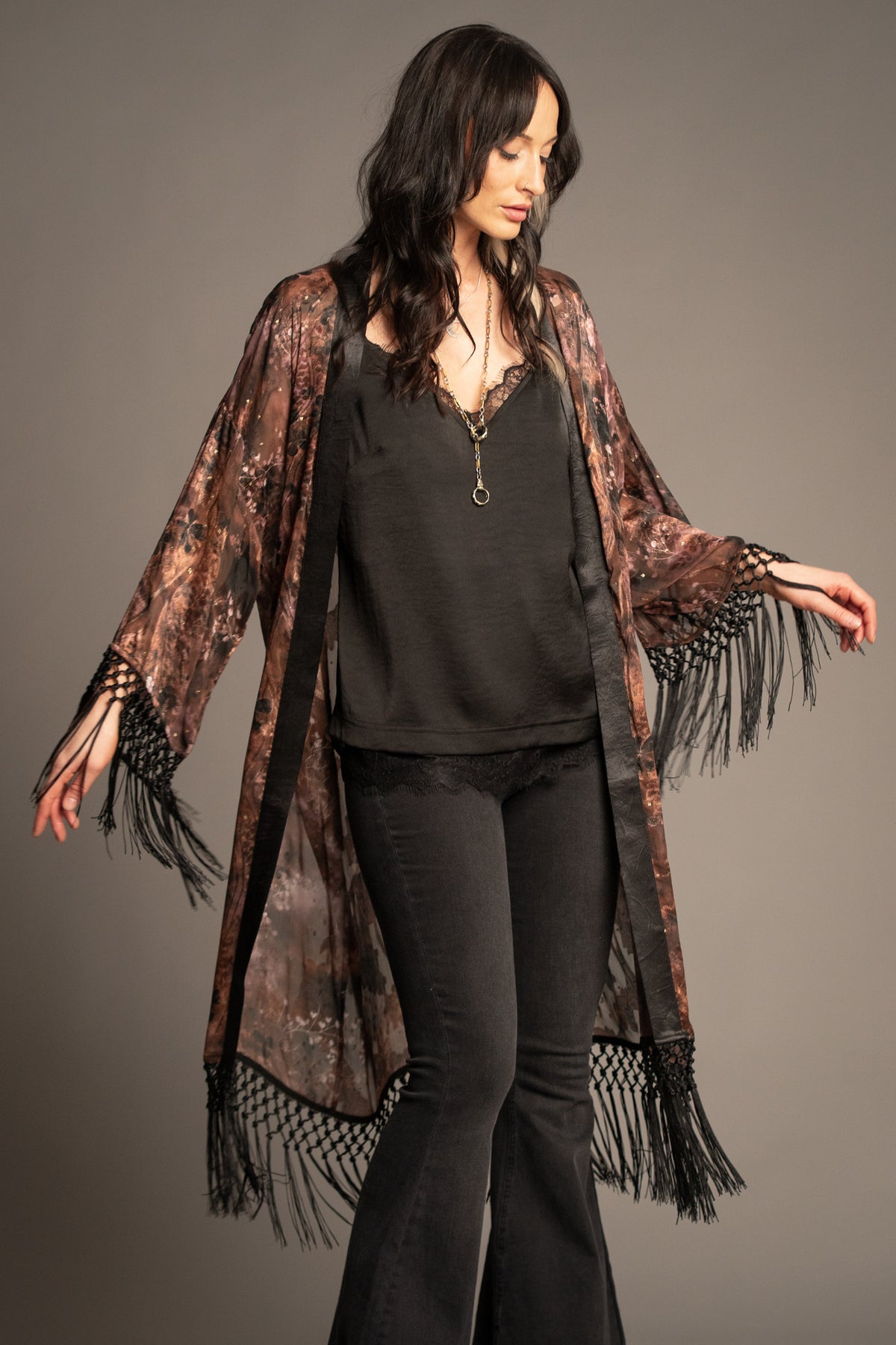 Practical Magic kimono showcasing vintage-inspired floral print, sheer fabric, black satin trim with statement tassel fringe cuffs and hem