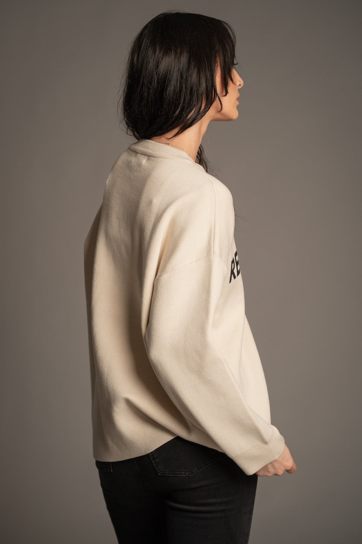 Victoria in the Rebel Rebel Cream Knit Jumper — back and side profile