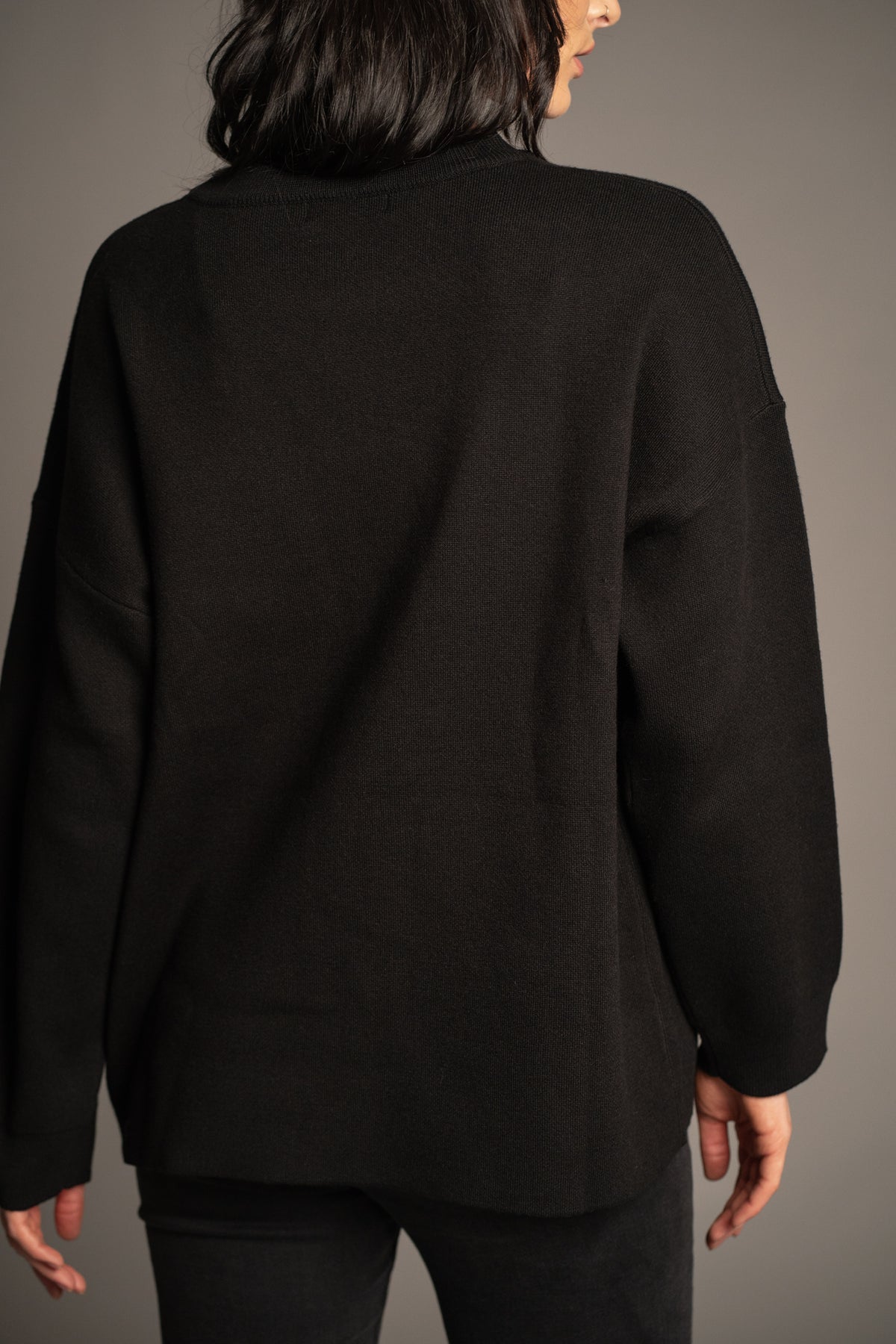 Back view of Rebel Rebel Knit Jumper in black with oversized silhouette and ribbed knit finish
